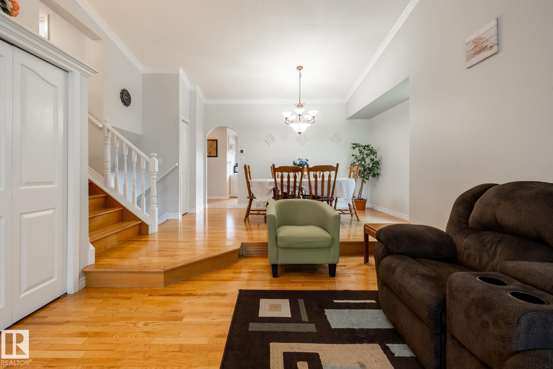 Hardwood flooring throughout the main level with a white baluster staircase - 27 Danforth Crescent, St. Albert, AB