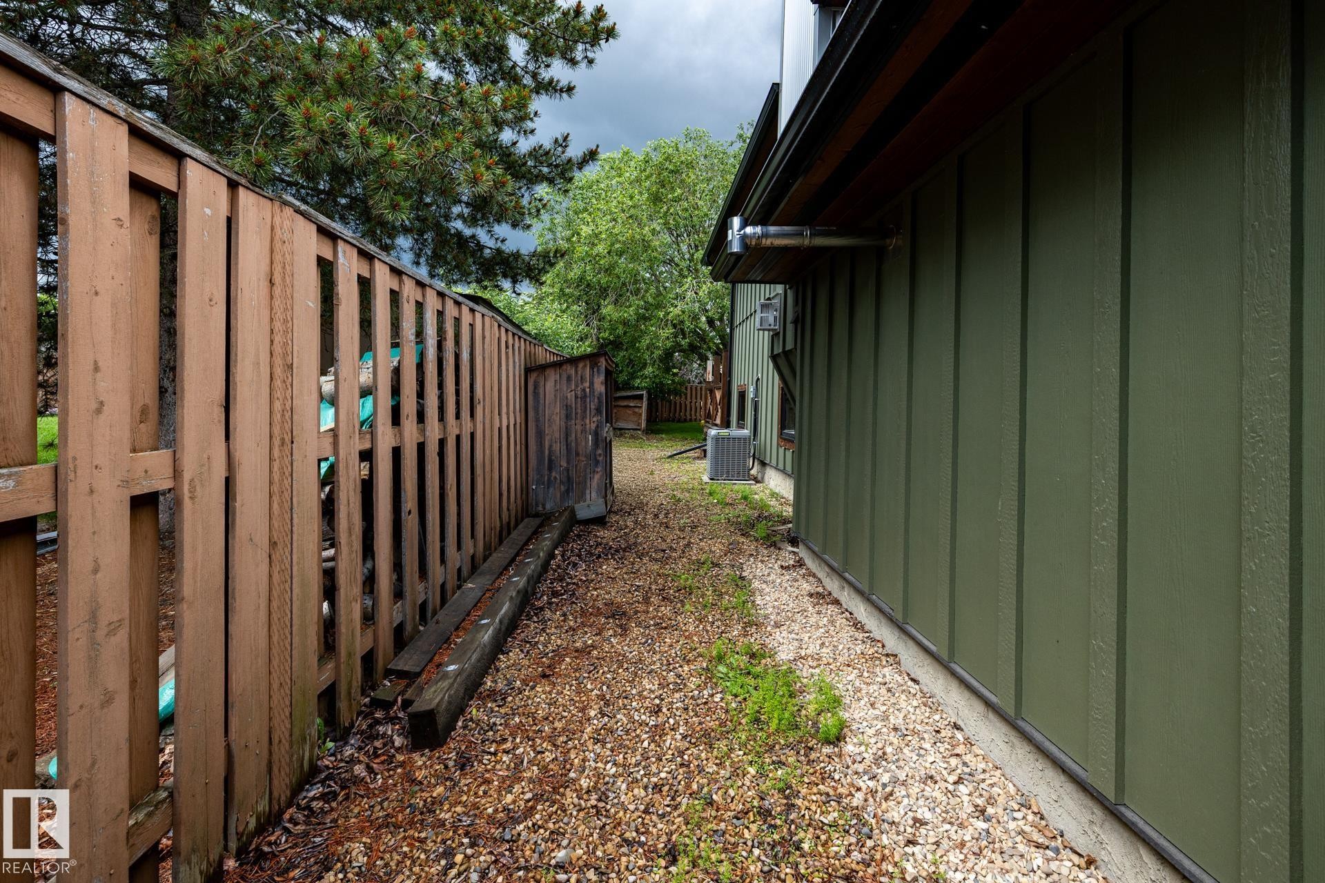 Side yard featuring gravel ground cover and board and batten siding - 27 Danforth Crescent, St. Albert, AB