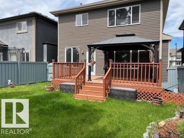 Rear exterior featuring a multi-level wood deck with railings, a built-in gazebo, and a grass lawn - 805 Hodgins Road Nw, Edmonton, AB - Outdoor With Deck Patio Veranda With Exterior