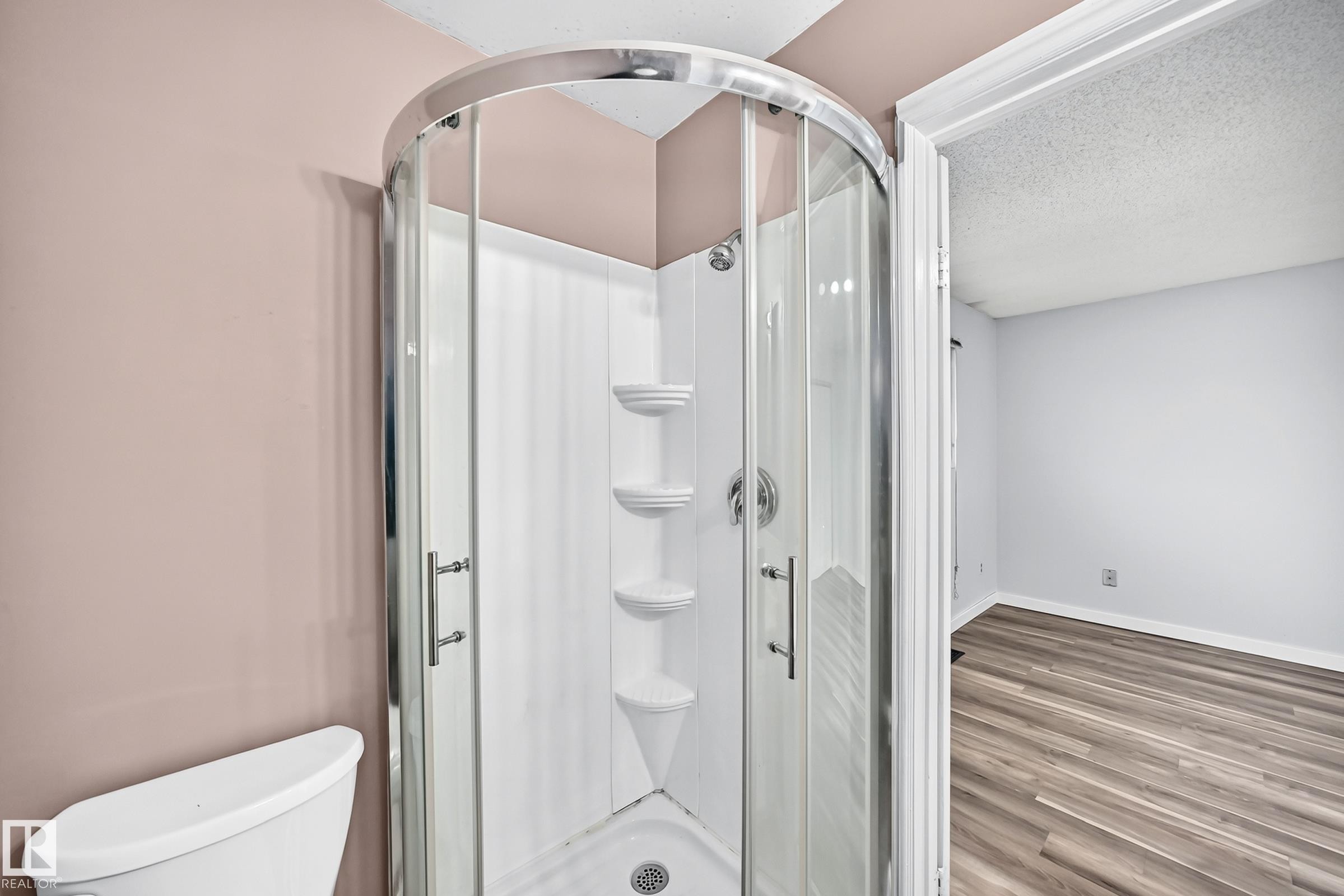 Corner shower enclosure with clear glass doors and chrome hardware - 1103 56 Street, Edmonton, AB