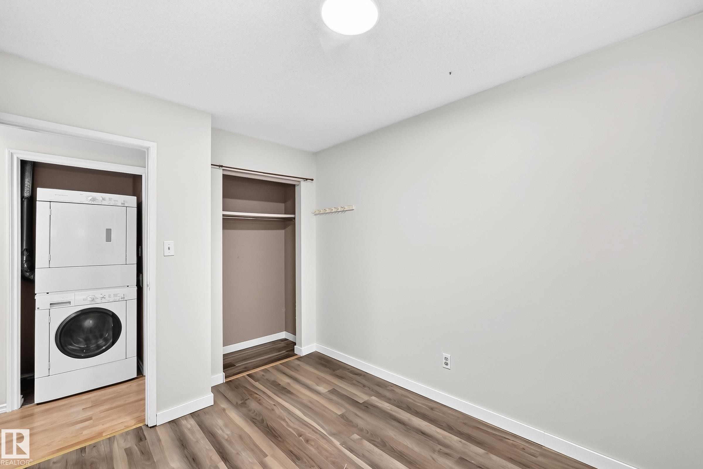 Interior room featuring wood-finish flooring, light-toned walls, and a ceiling-mounted light fixture - 1103 56 Street, Edmonton, AB
