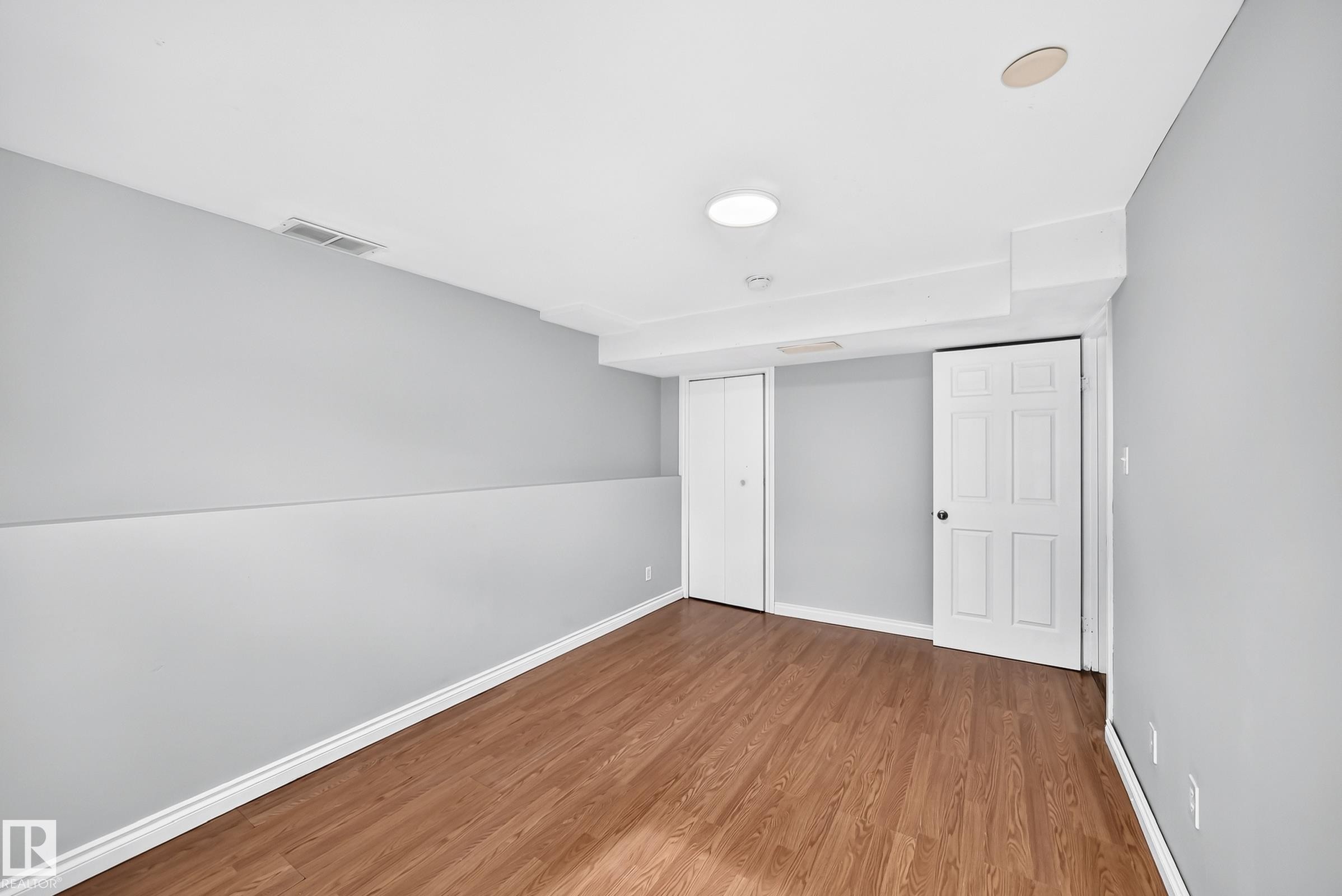 Wood-finish flooring with light gray walls and white trim - 1103 56 Street, Edmonton, AB