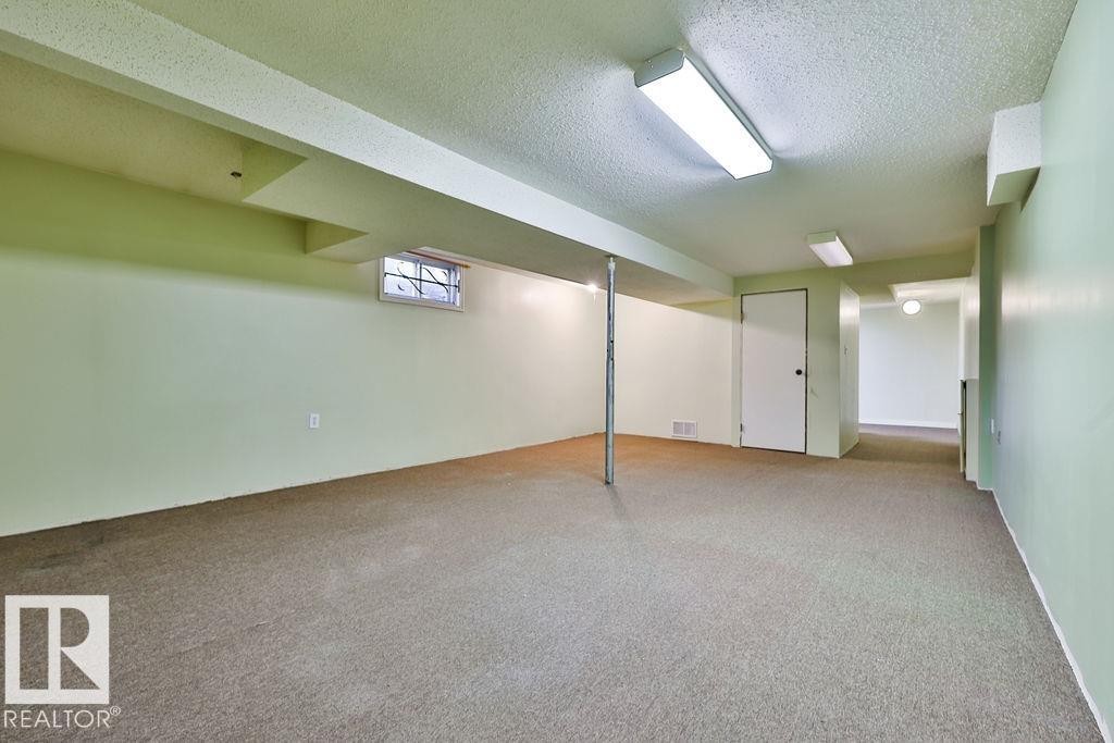 Spacious lower-level area featuring light green walls, exposed ceiling beams, and recessed lighting - 17009 109 Street, Edmonton, AB