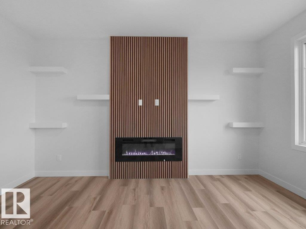 Feature wall with vertical wood slat detailing and an inset electric fireplace - 18719 130 Street Nw, Edmonton, AB