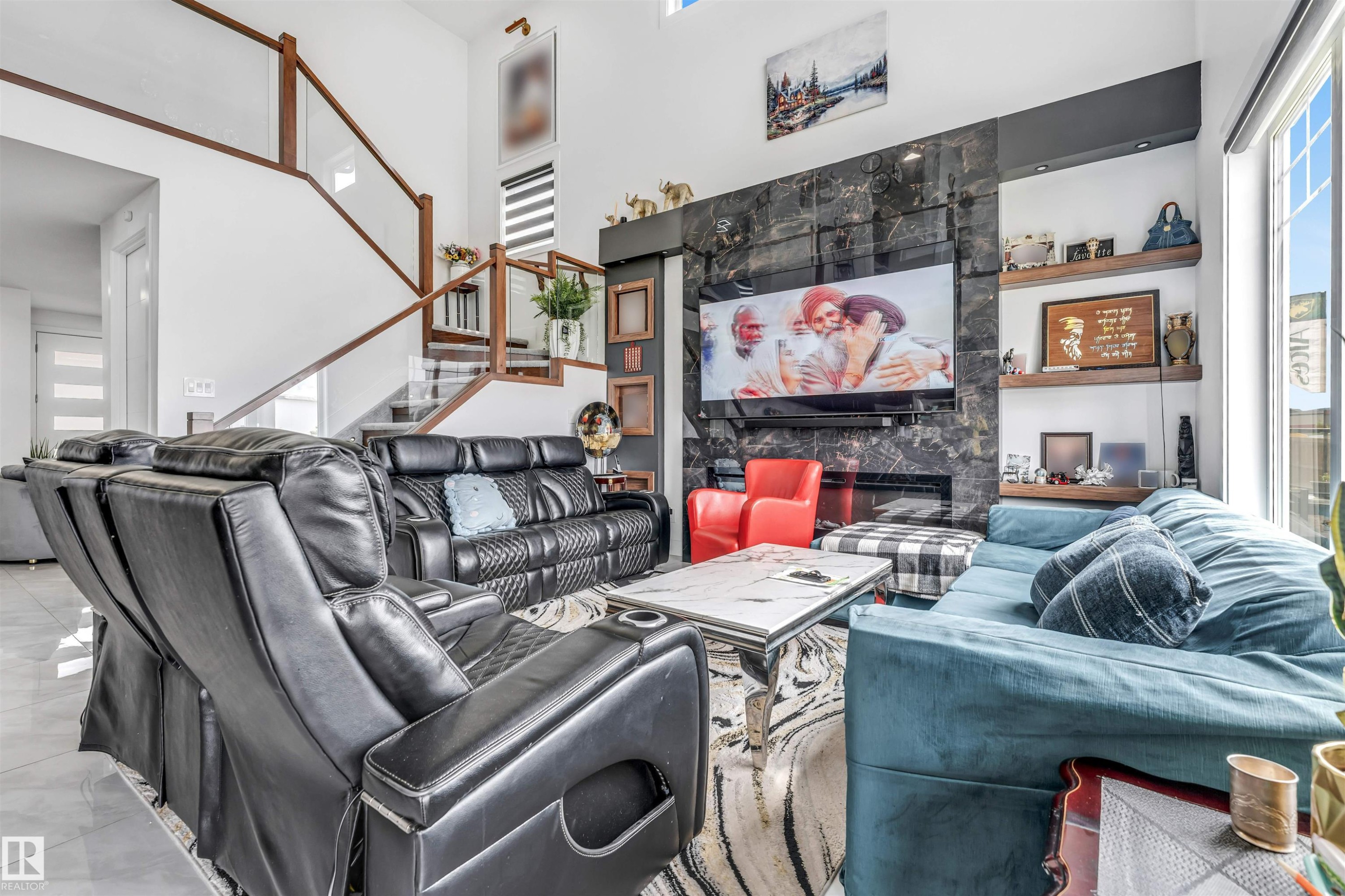 Two-story living area featuring a prominent dark stone-finish fireplace wall with an integrated television display - 208 33 Street, Edmonton, AB