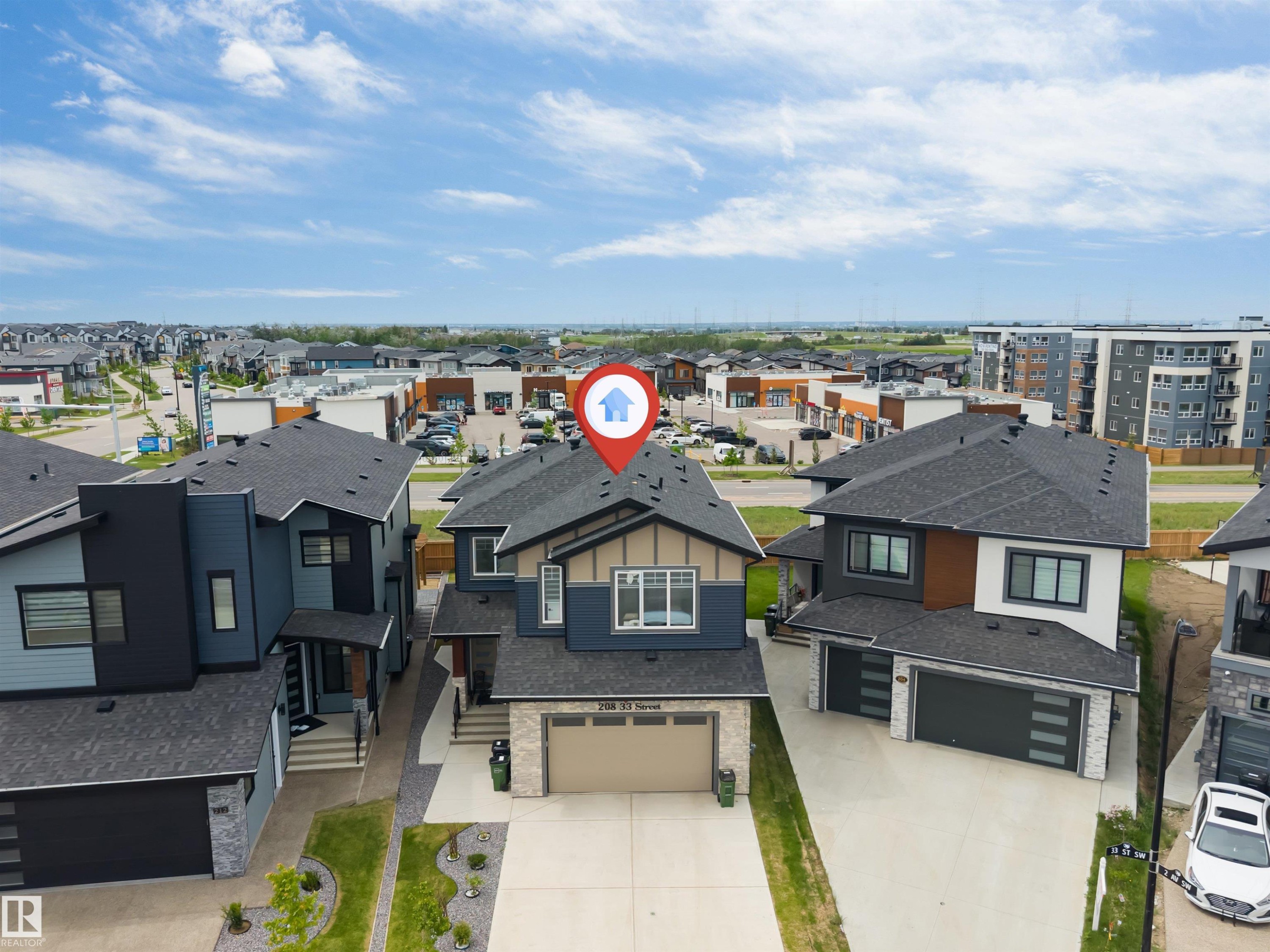 Contemporary two-story residence featuring a dark gray roof, light stone facade accents, and a two-car garage - 208 33 Street, Edmonton, AB