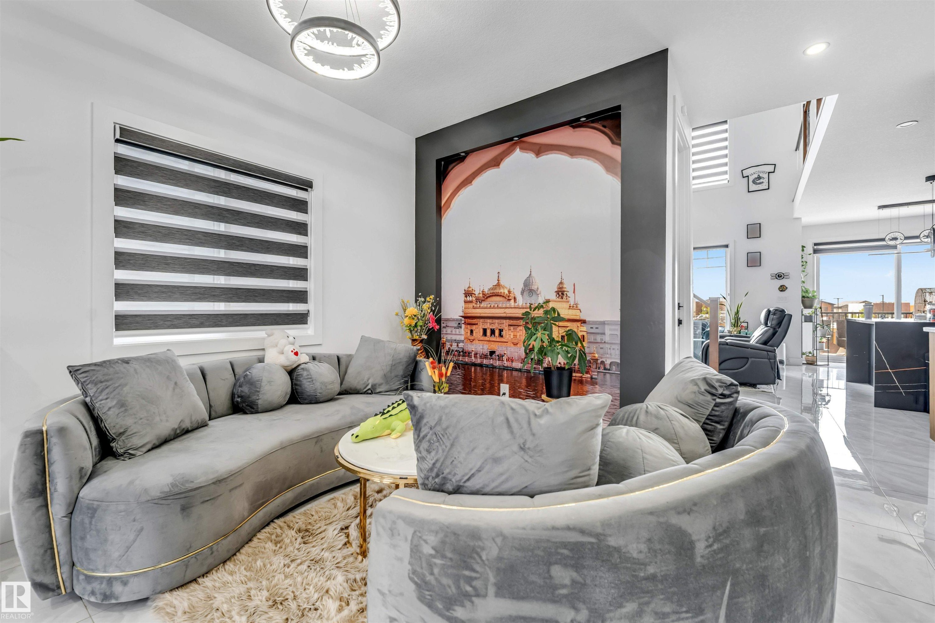 Living space featuring a striking accent wall, contemporary lighting fixtures, and polished tile flooring - 208 33 Street, Edmonton, AB