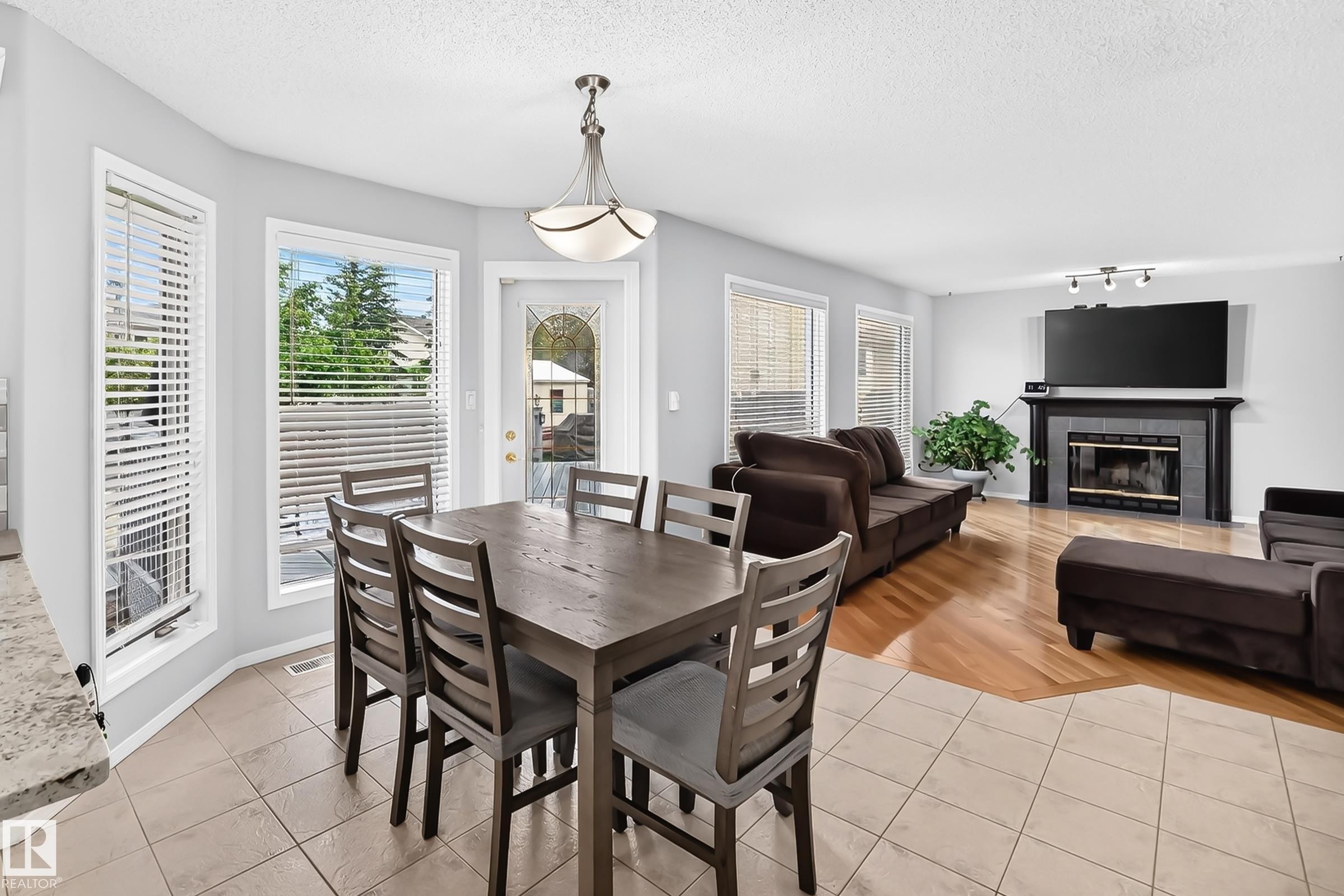 Dining area with tile flooring and multiple windows, featuring a decorative glass door - 4216 47 Street, Edmonton, AB