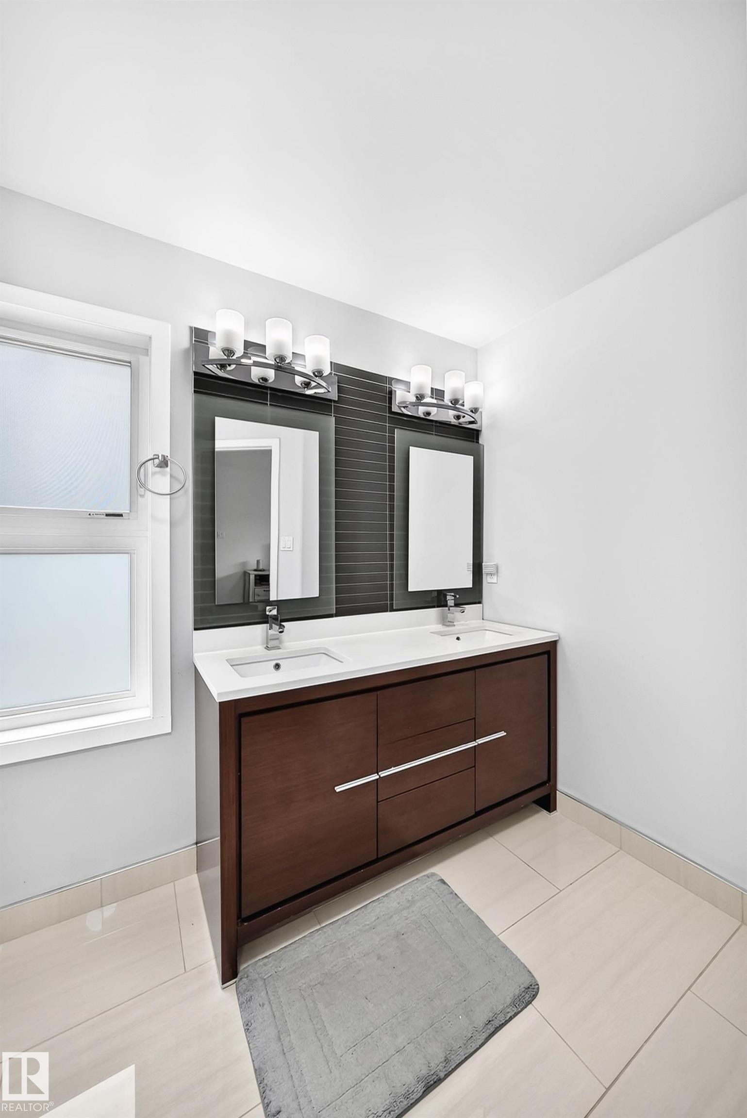Dual vanity featuring a wood-finish cabinet with chrome hardware, integrated sinks, and individual mirrors - 4216 47 Street, Edmonton, AB