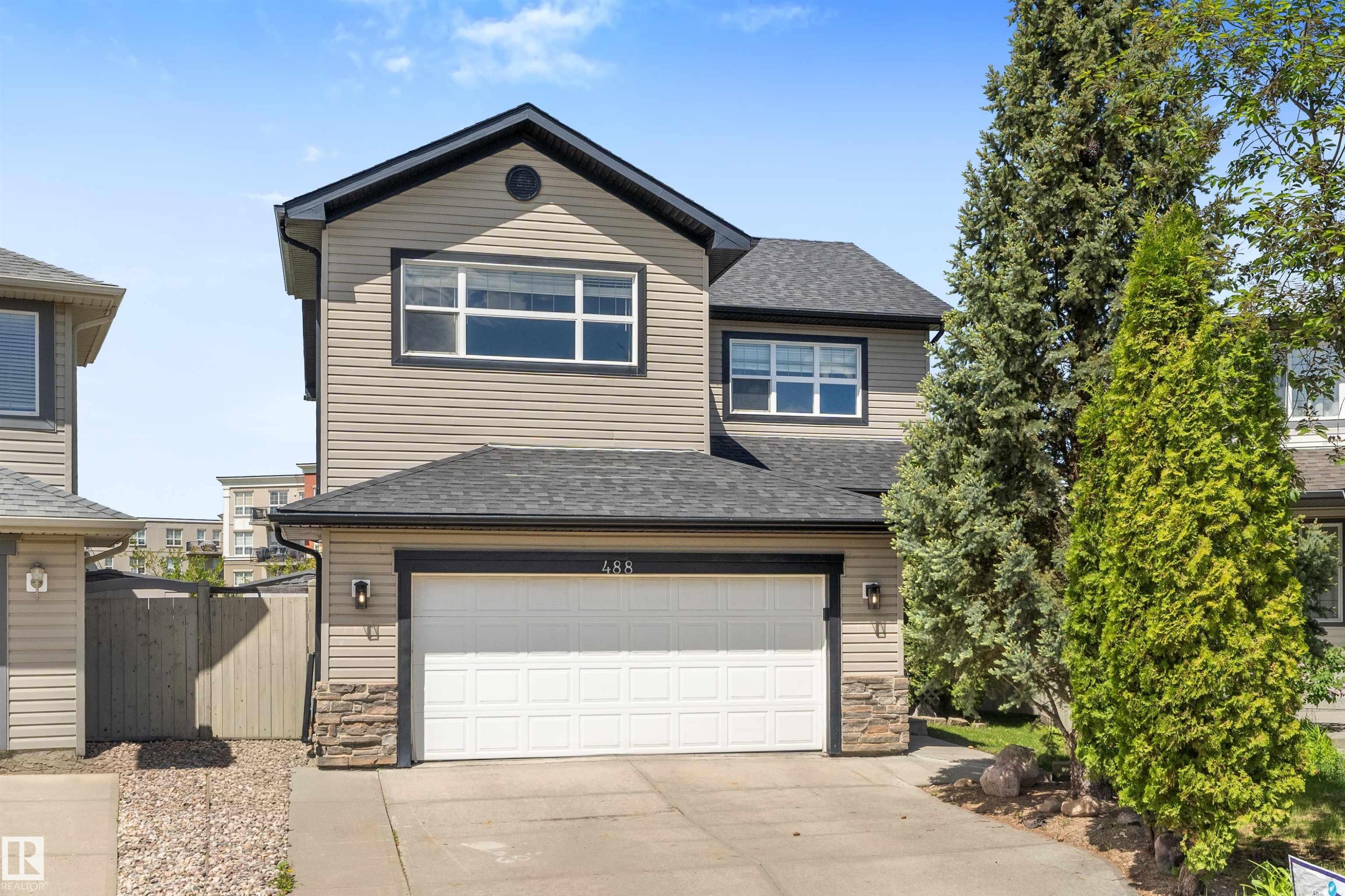 Two-story residence featuring light-toned siding, a dark shingled roof, and dark trim - 488 Macewan Road, Edmonton, AB
