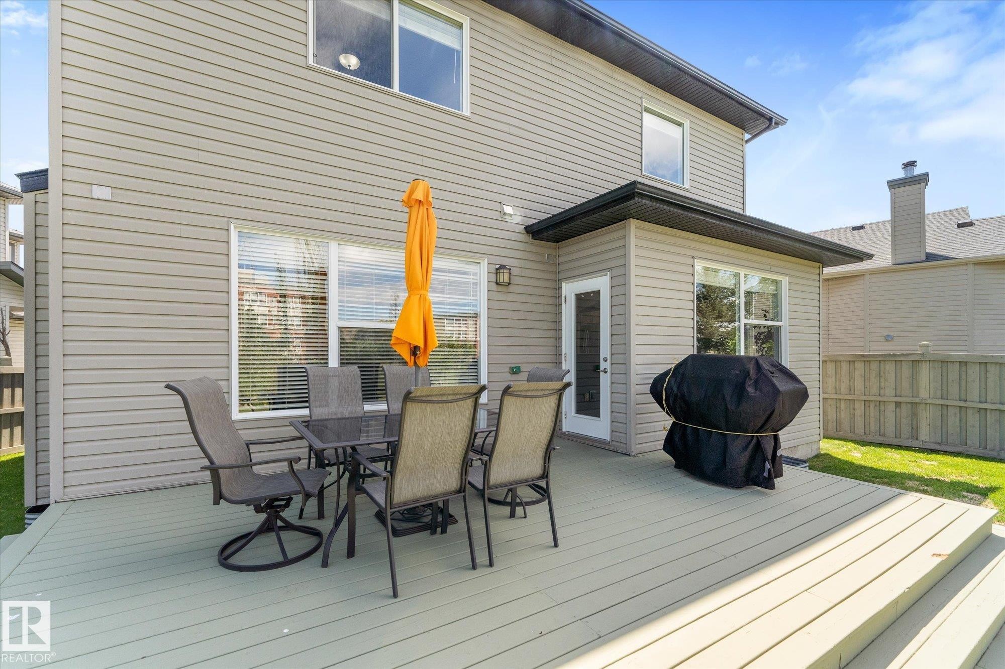 Expansive wood-finish deck with integrated steps, offering ample outdoor living space - 488 Macewan Road, Edmonton, AB