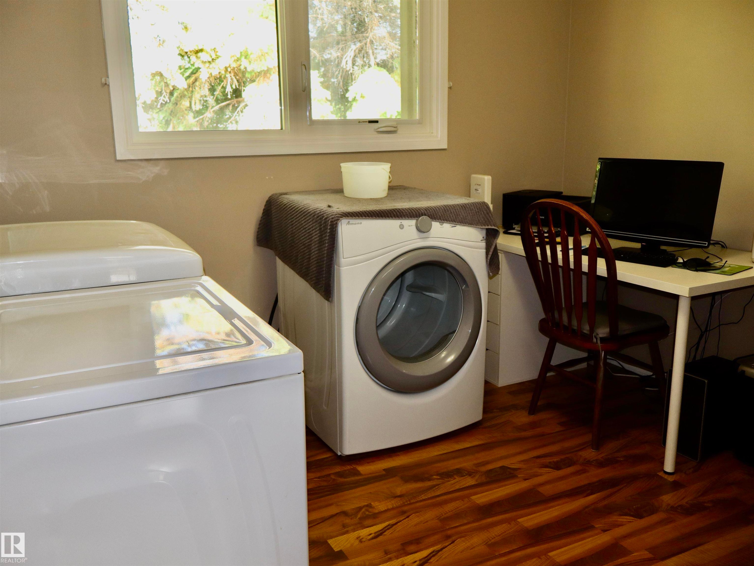 Dedicated laundry area featuring a top-load washing machine and a front-load dryer - 5530 46 Street, Barrhead, AB