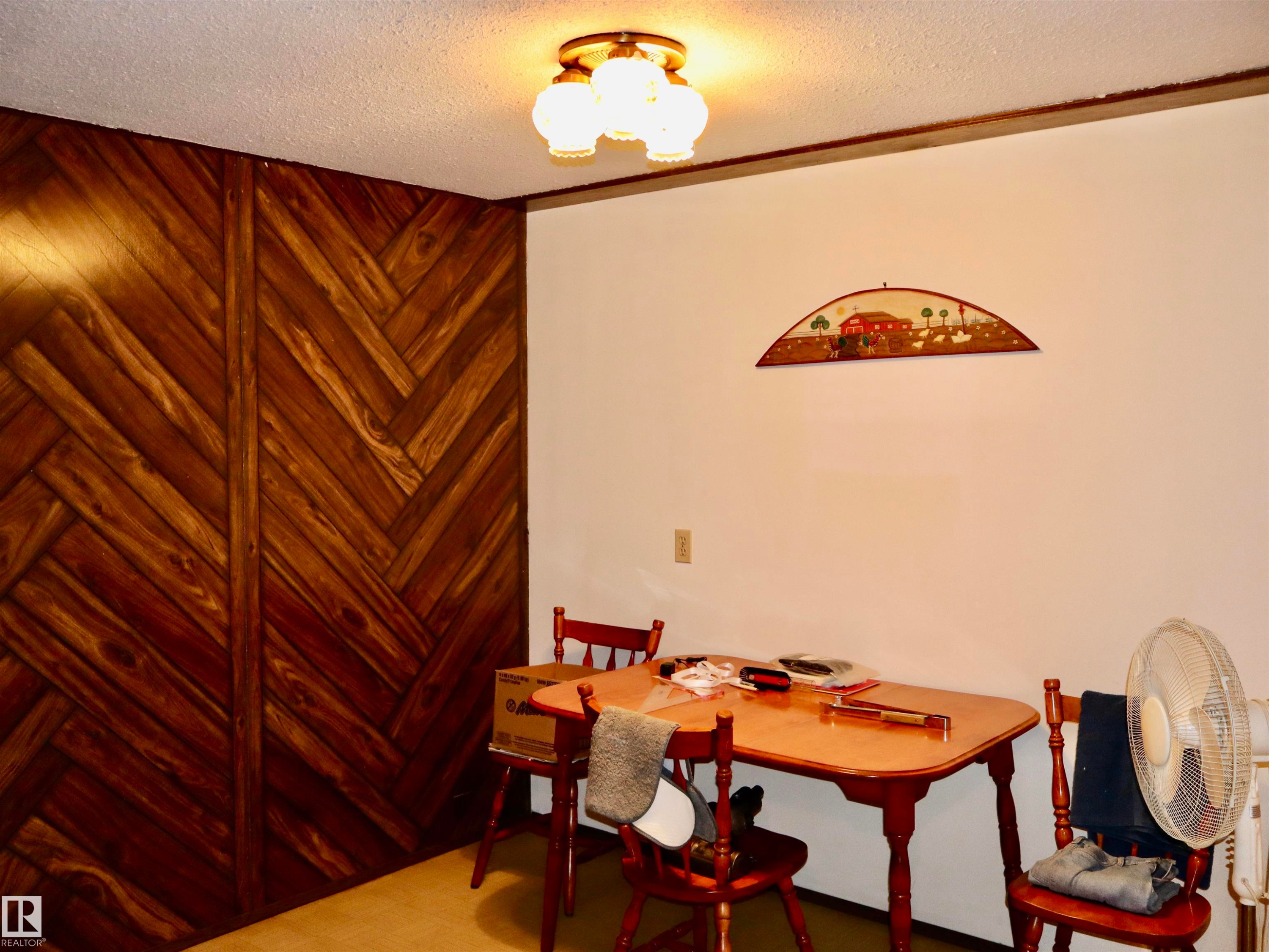 Herringbone wood-finish accent wall with a textured ceiling and a three-light flush mount fixture - 5530 46 Street, Barrhead, AB