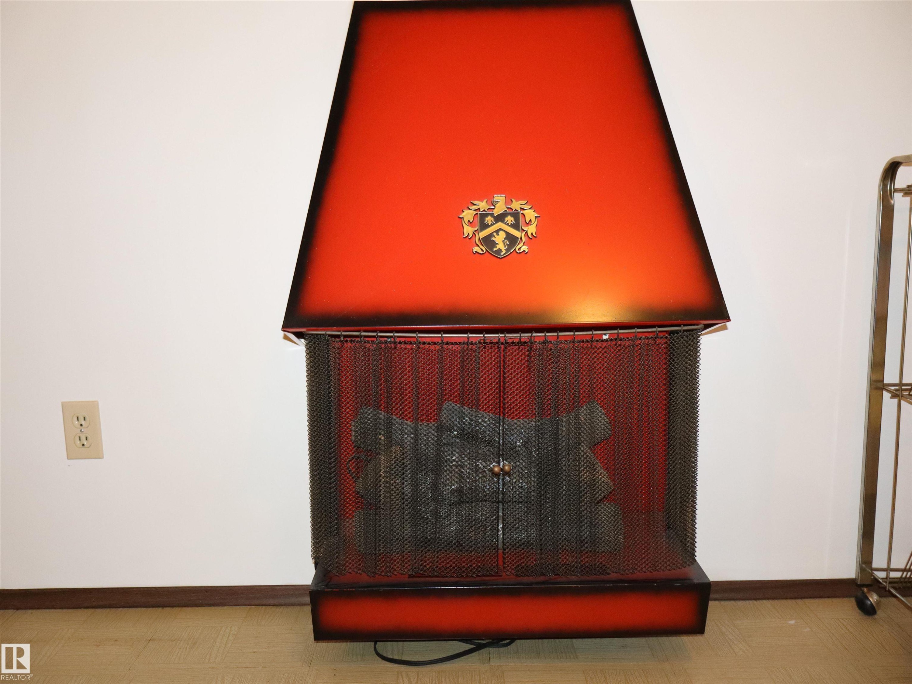 Freestanding fireplace featuring a vibrant red and black ombré finish - 5530 46 Street, Barrhead, AB