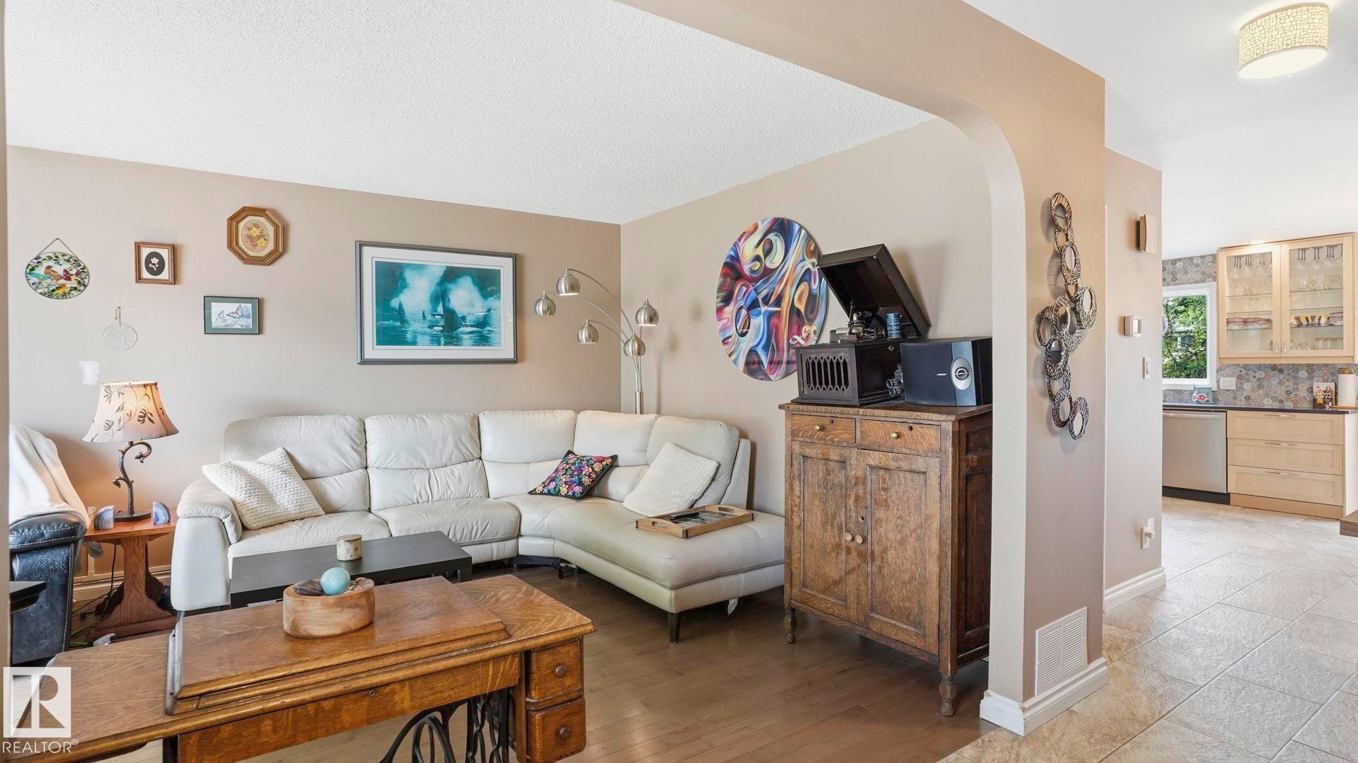 Open-concept living space featuring wood-finish flooring and a neutral color palette - 1827 36 Street Nw, Edmonton, AB