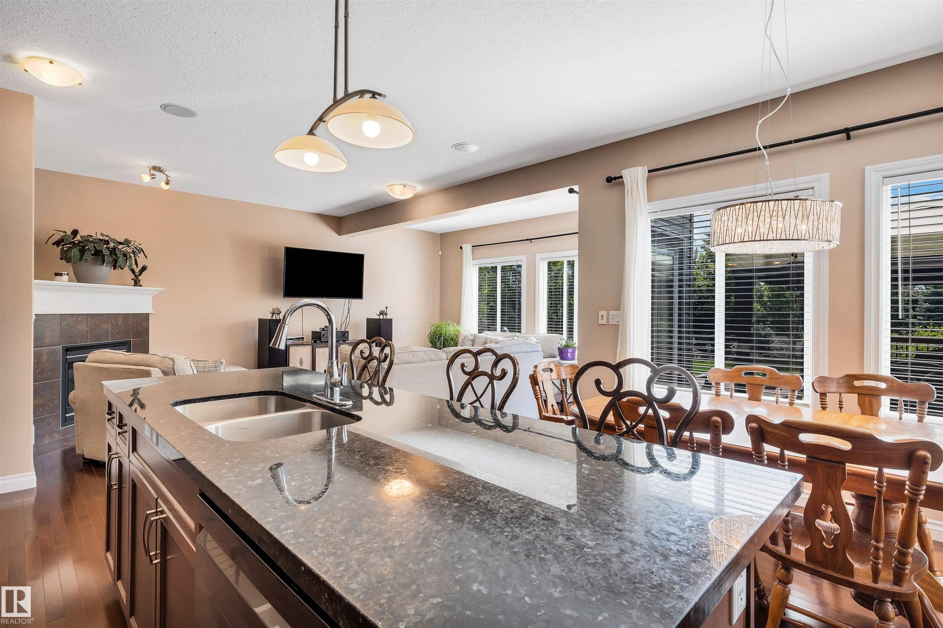 Kitchen island featuring a double basin stainless steel sink, a high-arc faucet, and a stone-finish countertop - 18 Voleta Crest, Spruce Grove, AB