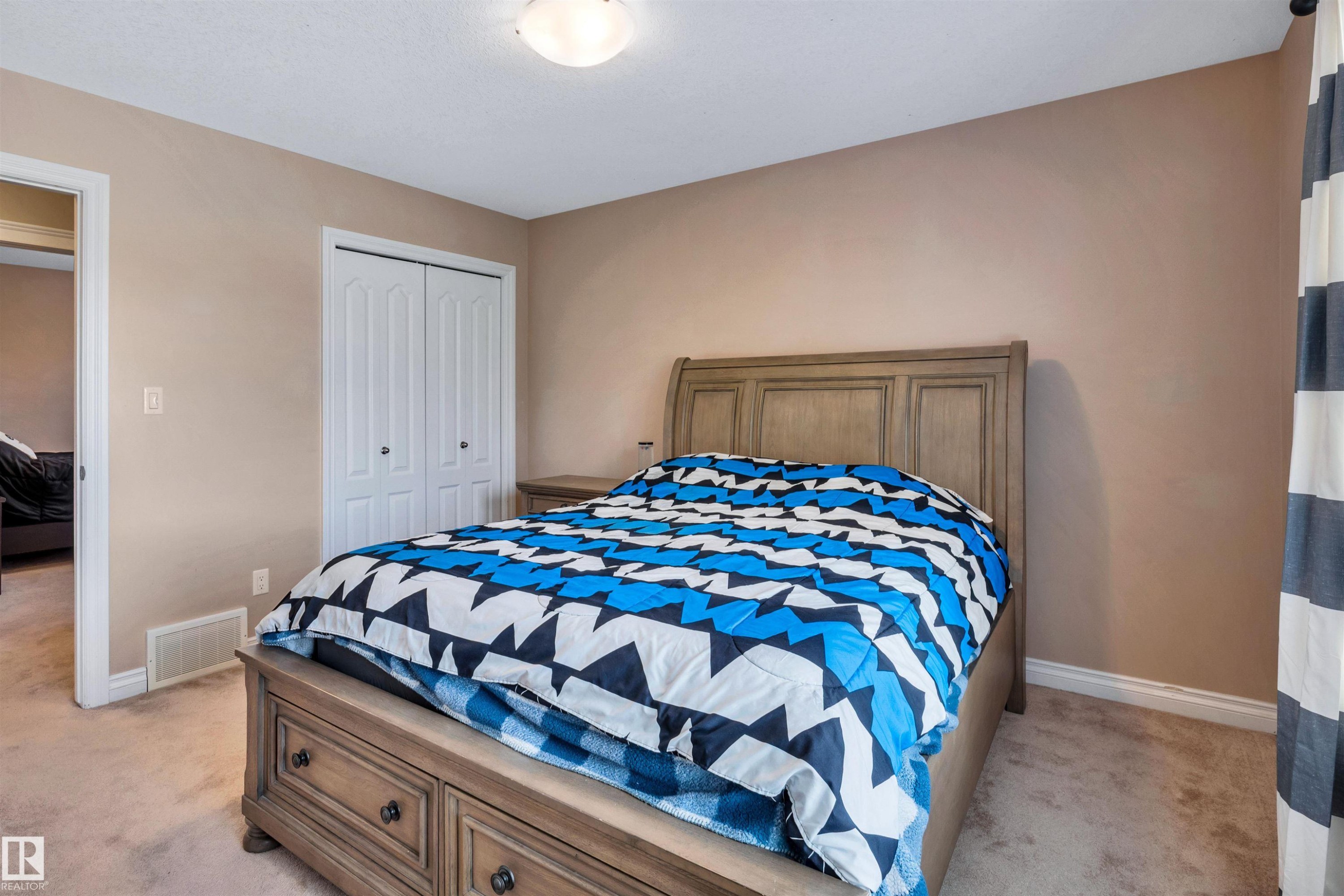 Bedroom featuring neutral wall paint, light-colored carpeting, and a flush-mount ceiling light - 18 Voleta Crest, Spruce Grove, AB
