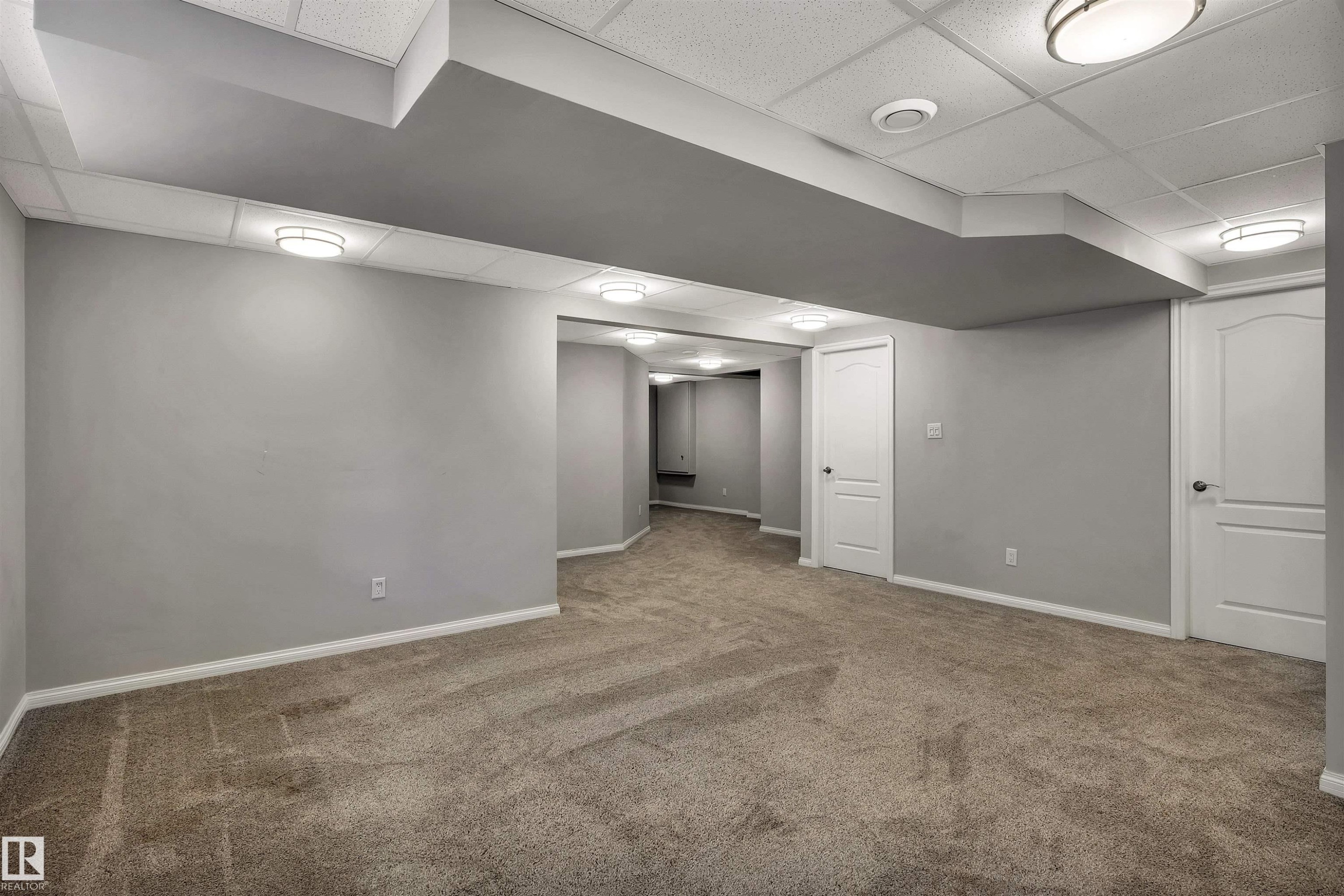 Carpeted interior space featuring light gray walls, white baseboards, and white paneled doors - 18 Voleta Crest, Spruce Grove, AB