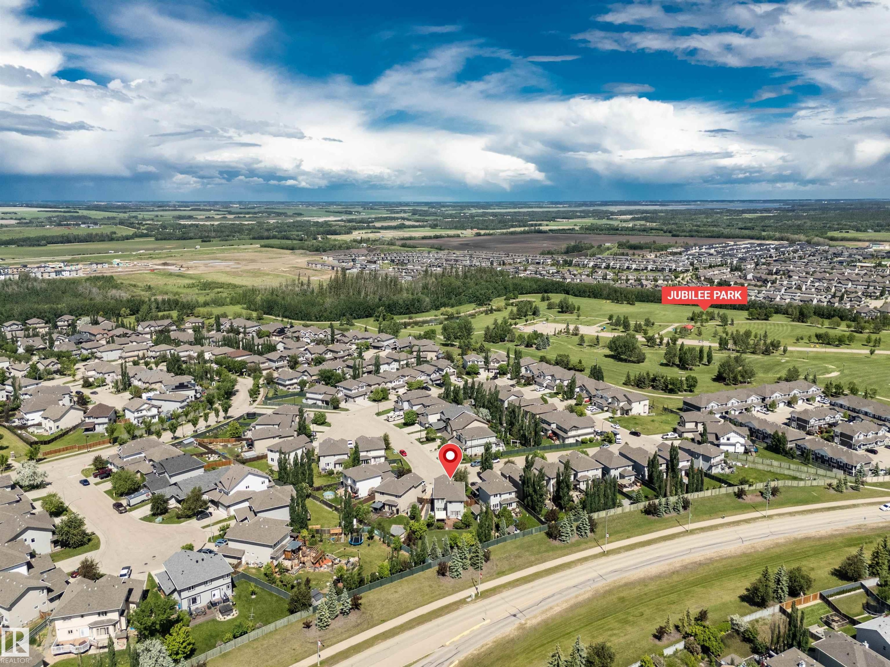 Aerial overview of a residential development featuring numerous single-family homes and Jubilee Park - 18 Voleta Crest, Spruce Grove, AB