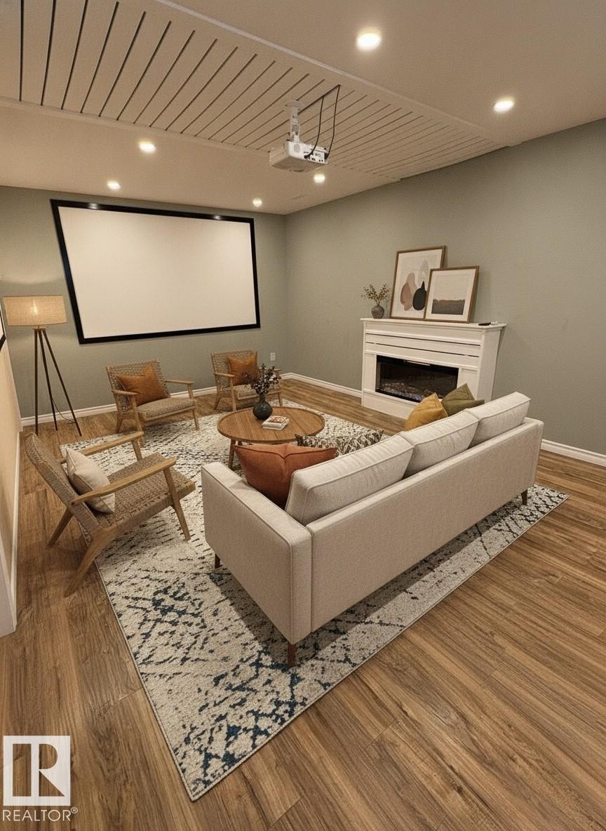 Media room featuring a large projection screen and wood-finish flooring - 21354 87A Avenue, Edmonton, AB