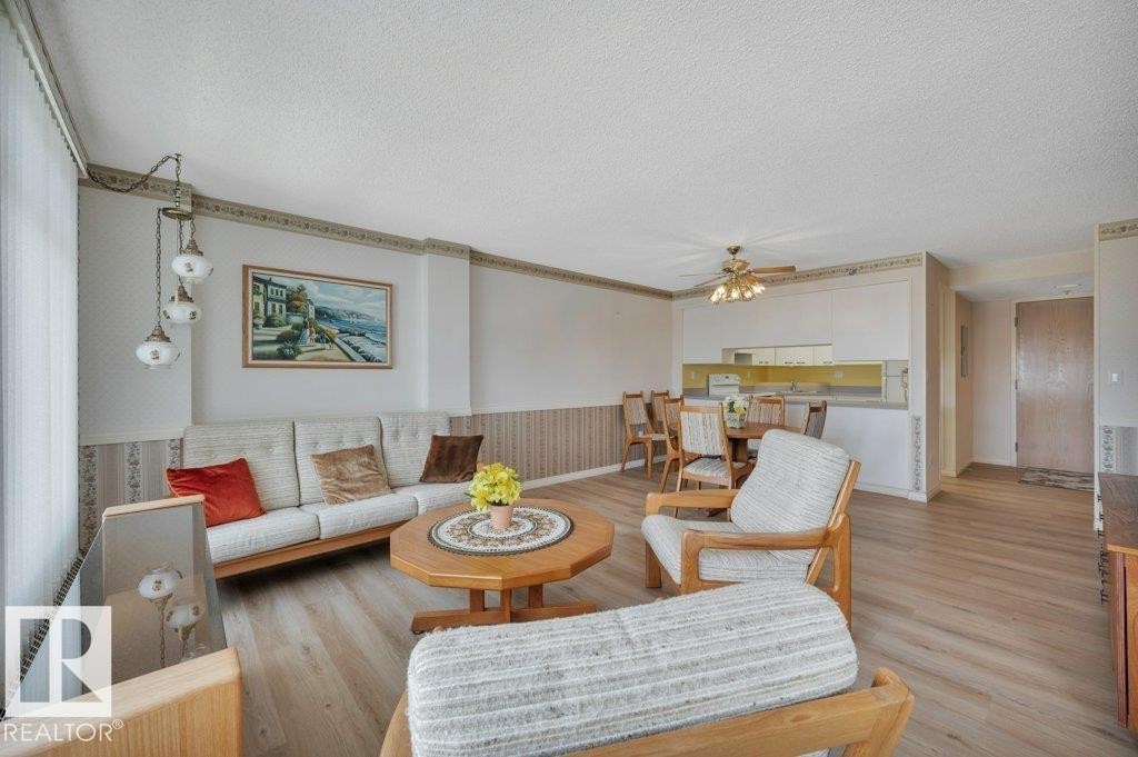 Open-concept living space featuring wood-finish flooring and a multi-light pendant fixture - 316 2011 137 Avenue, Edmonton, AB - Indoor Photo Showing Living Room