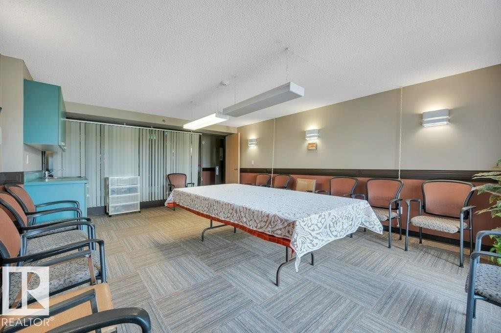 Common area featuring patterned carpet flooring and a built-in refreshment counter with a sink and storage cabinetry - 316 2011 137 Avenue, Edmonton, AB - Indoor