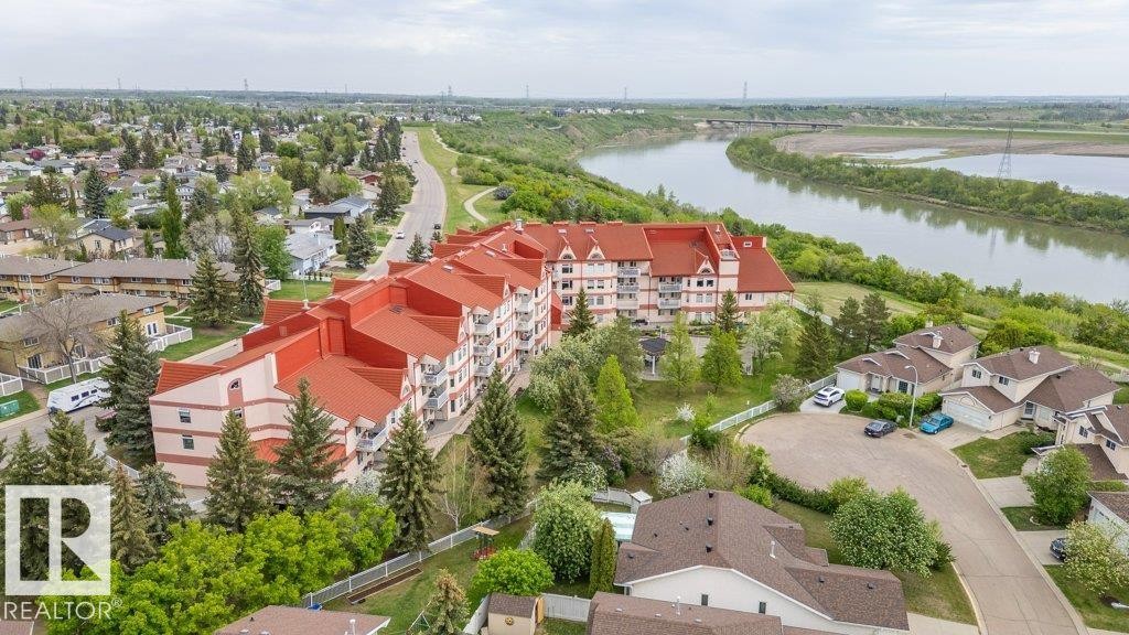 Expansive multi-story building featuring a red roofline and numerous balconies - 316 2011 137 Avenue, Edmonton, AB - Outdoor With Body Of Water With View