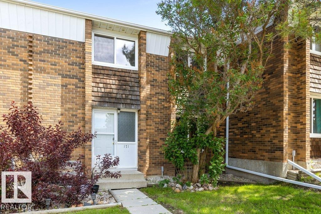 Brick and wood-shingle exterior featuring white trim and a concrete walkway - 171 Ridgewood, St. Albert, AB