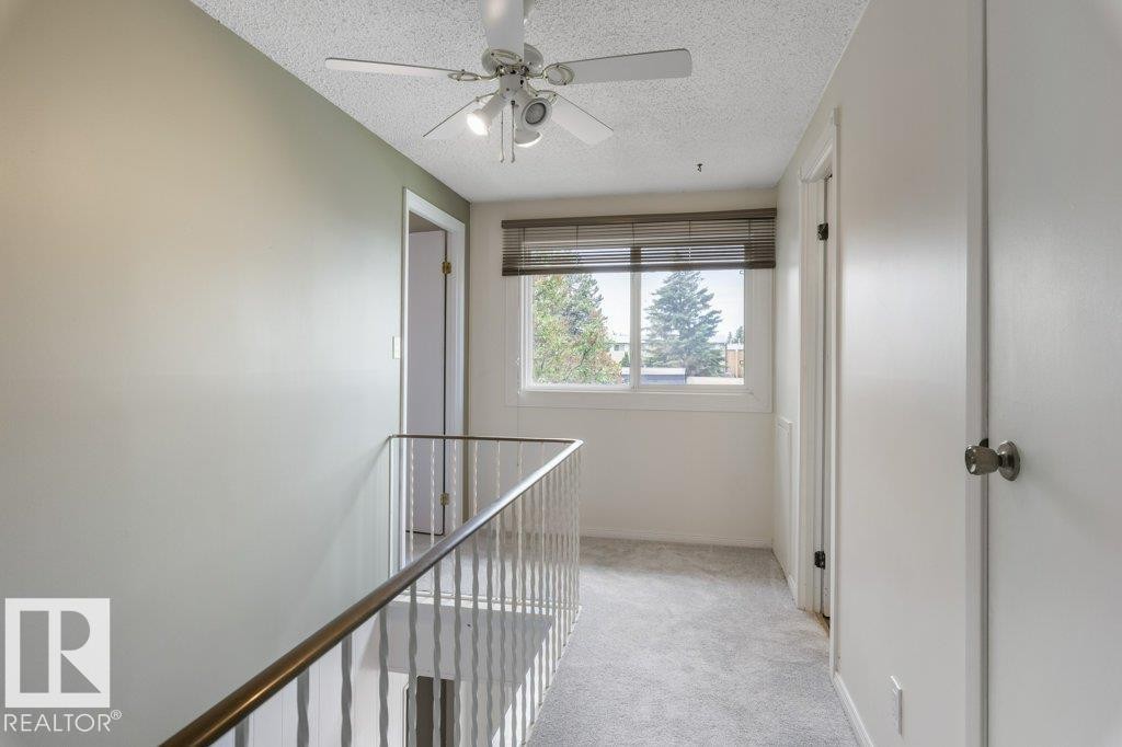 Upper-level landing featuring light gray carpeting and a white ceiling fan - 171 Ridgewood, St. Albert, AB