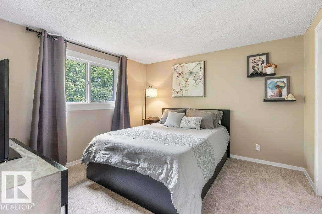 Carpeted room with a double-pane window, neutral-toned walls, and a textured ceiling - 171 Ridgewood, St. Albert, AB