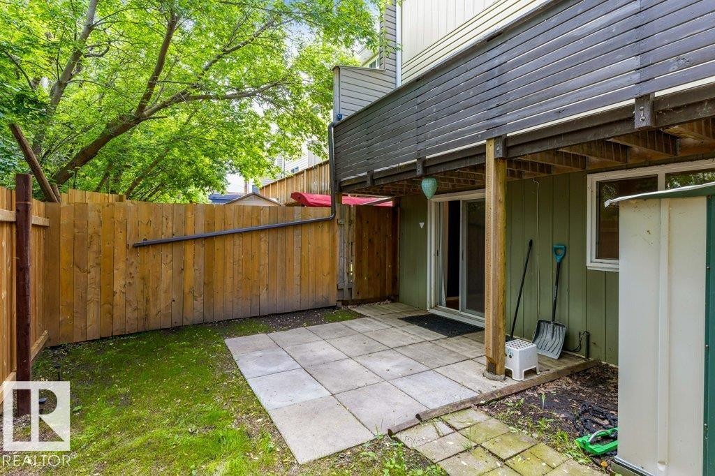 Private patio area with concrete pavers and a wood privacy fence - 171 Ridgewood, St. Albert, AB