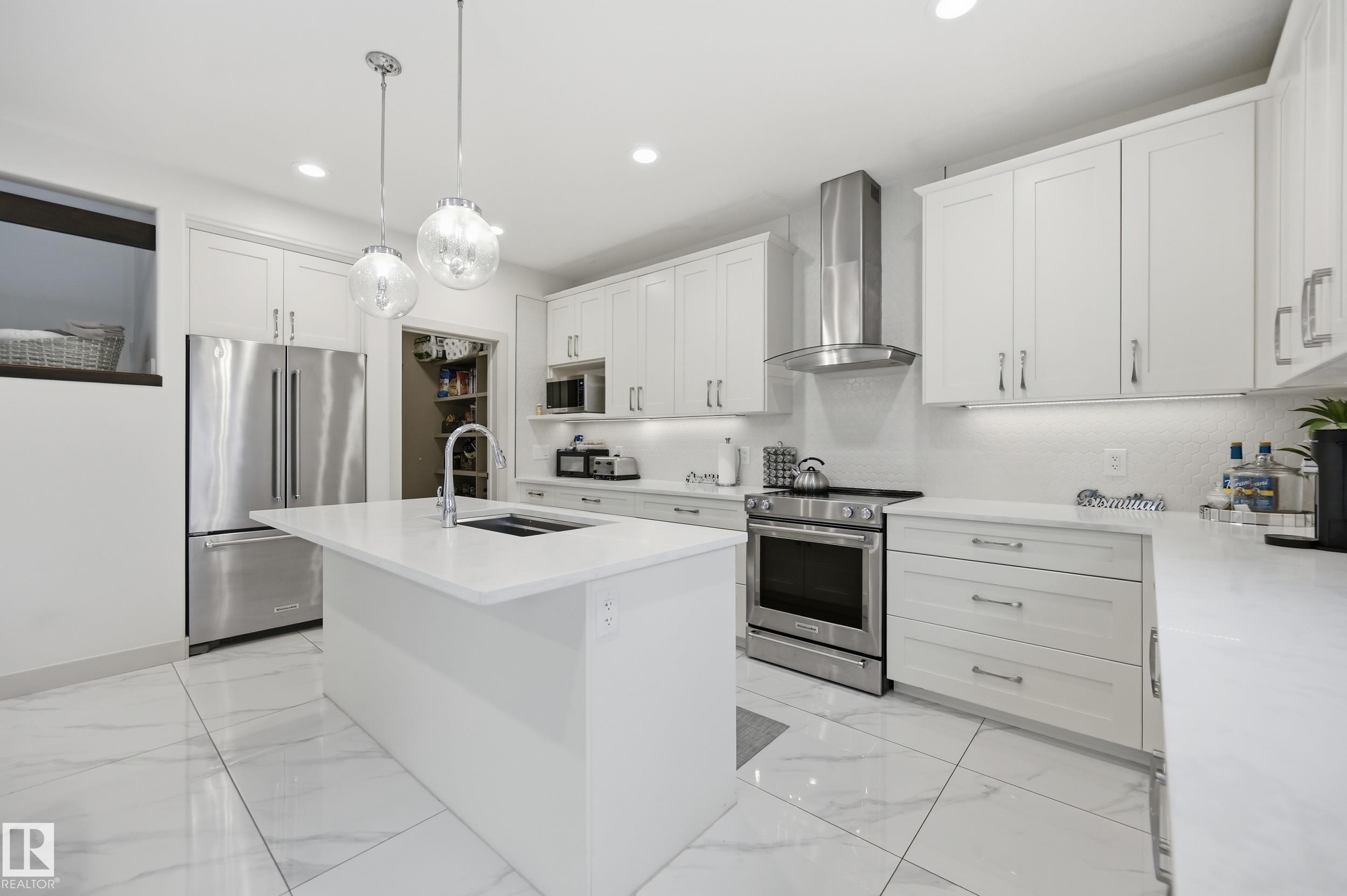 Kitchen featuring a central island, white shaker-style cabinetry, and stainless steel appliances - 76 Jacobs Close, St. Albert, AB