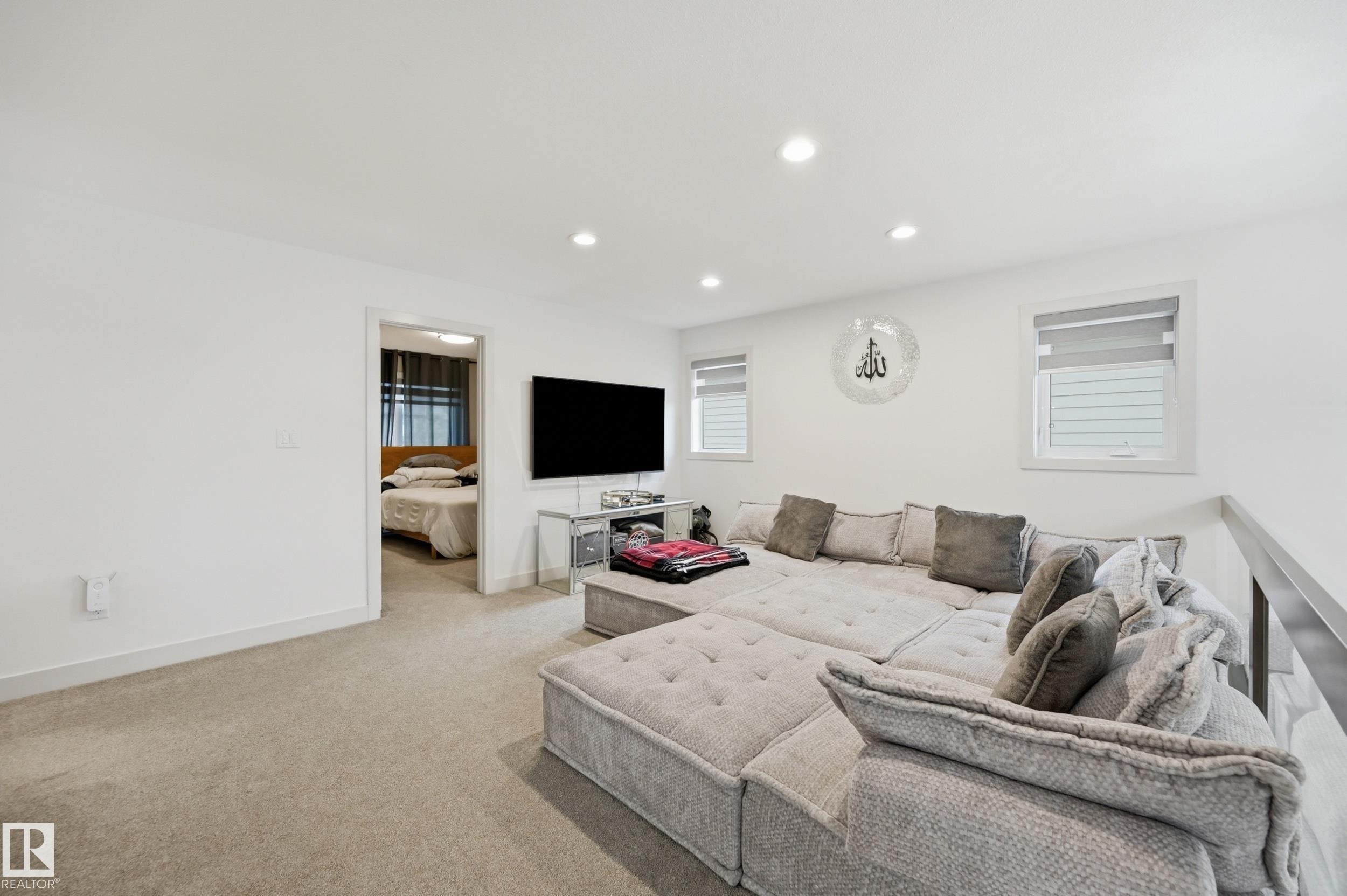 White walls with recessed lighting, carpet flooring, multiple windows with blinds, and a partial hallway opening - 76 Jacobs Close, St. Albert, AB