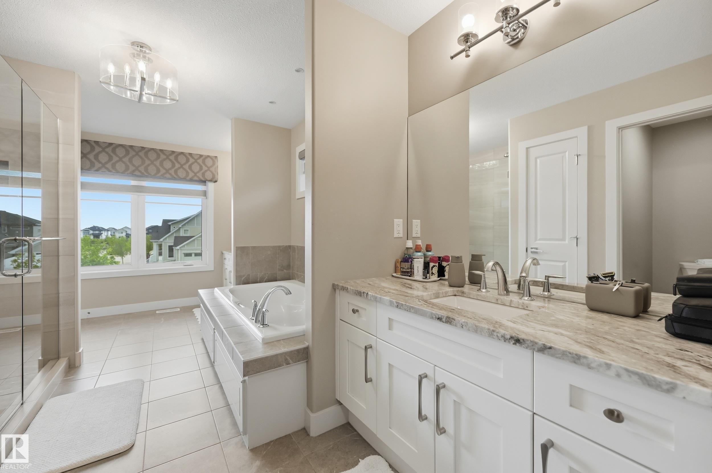 Contemporary bathroom featuring a spacious vanity with an undermount sink, a marble-patterned countertop, and white cabinetry - 76 Jacobs Close, St. Albert, AB