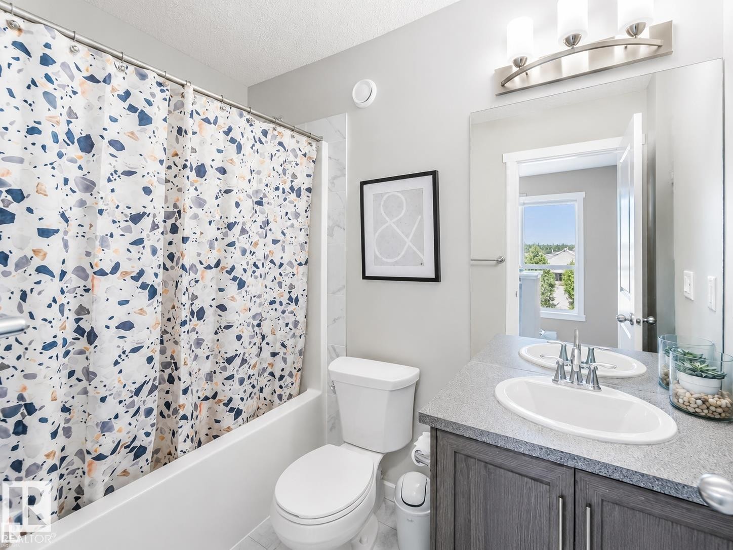 Contemporary bathroom featuring a single vanity with a white oval sink, brushed nickel faucet, and a large frameless mirror - 1908 25 Street Nw, Edmonton, AB
