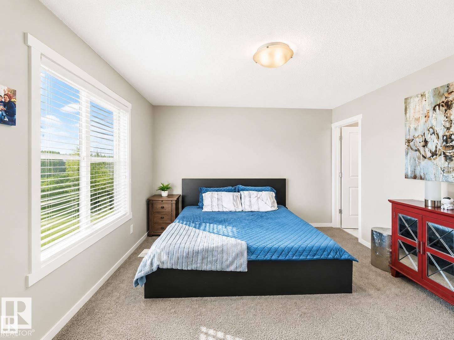 Bright room with a large window and blinds, light gray walls, and carpet flooring - 1908 25 Street Nw, Edmonton, AB