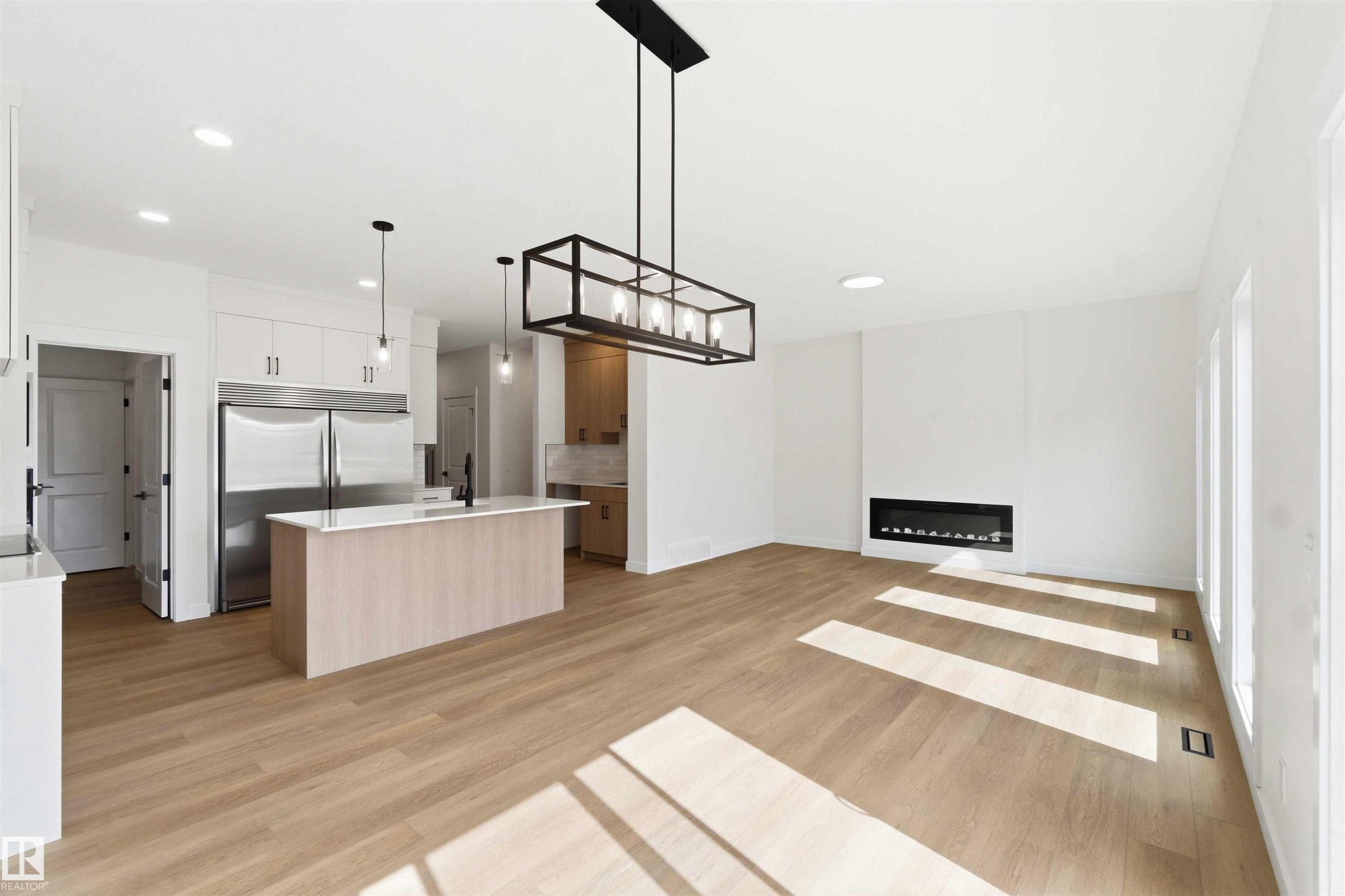 Open-concept living space with light wood-finish flooring - 1085 Cristall Crescent Sw, Edmonton, AB - Indoor