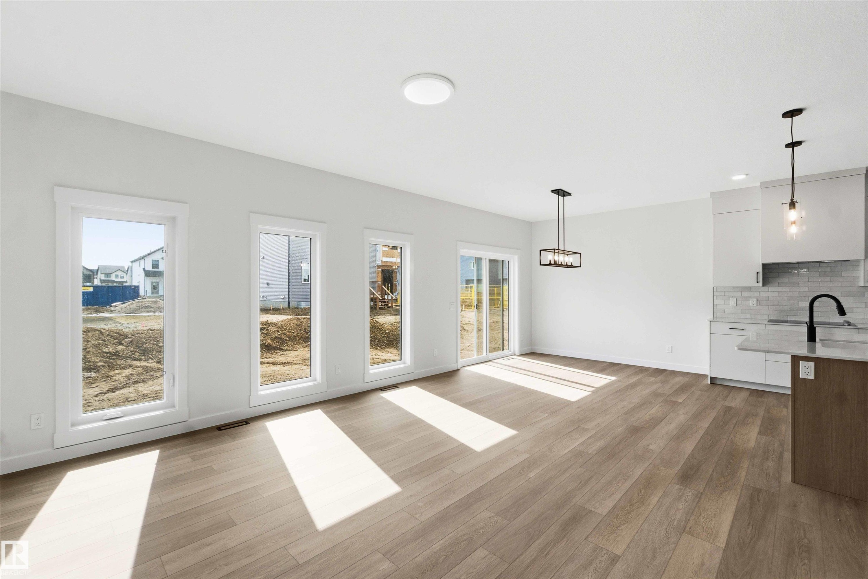 Open-concept living space featuring wood-finish flooring, white walls, and recessed lighting - 1085 Cristall Crescent Sw, Edmonton, AB - Indoor