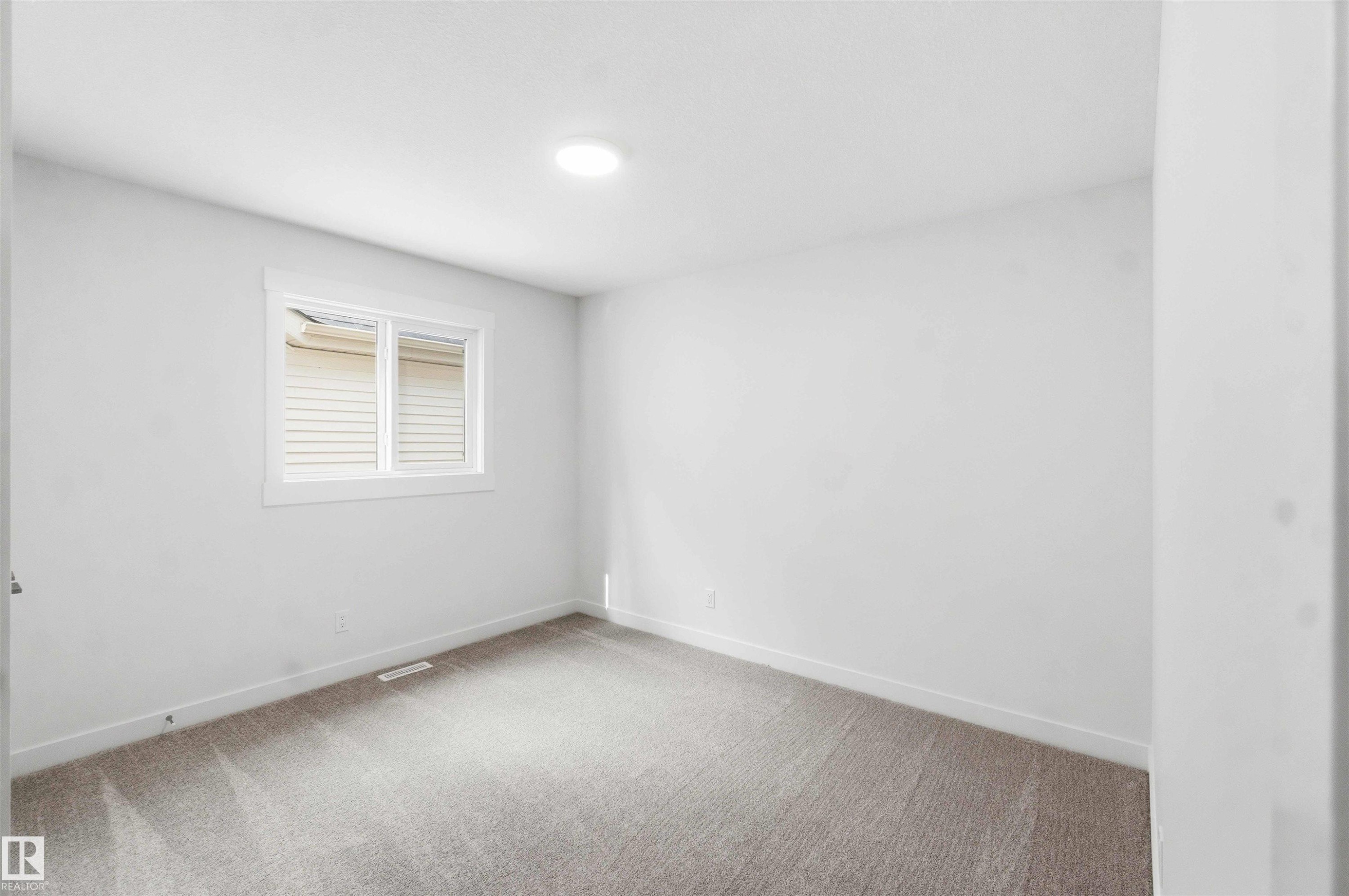 Carpeted room with a white-framed window, white walls, and a ceiling-mounted light fixture - 1085 Cristall Crescent Sw, Edmonton, AB - Indoor Photo Showing Other Room