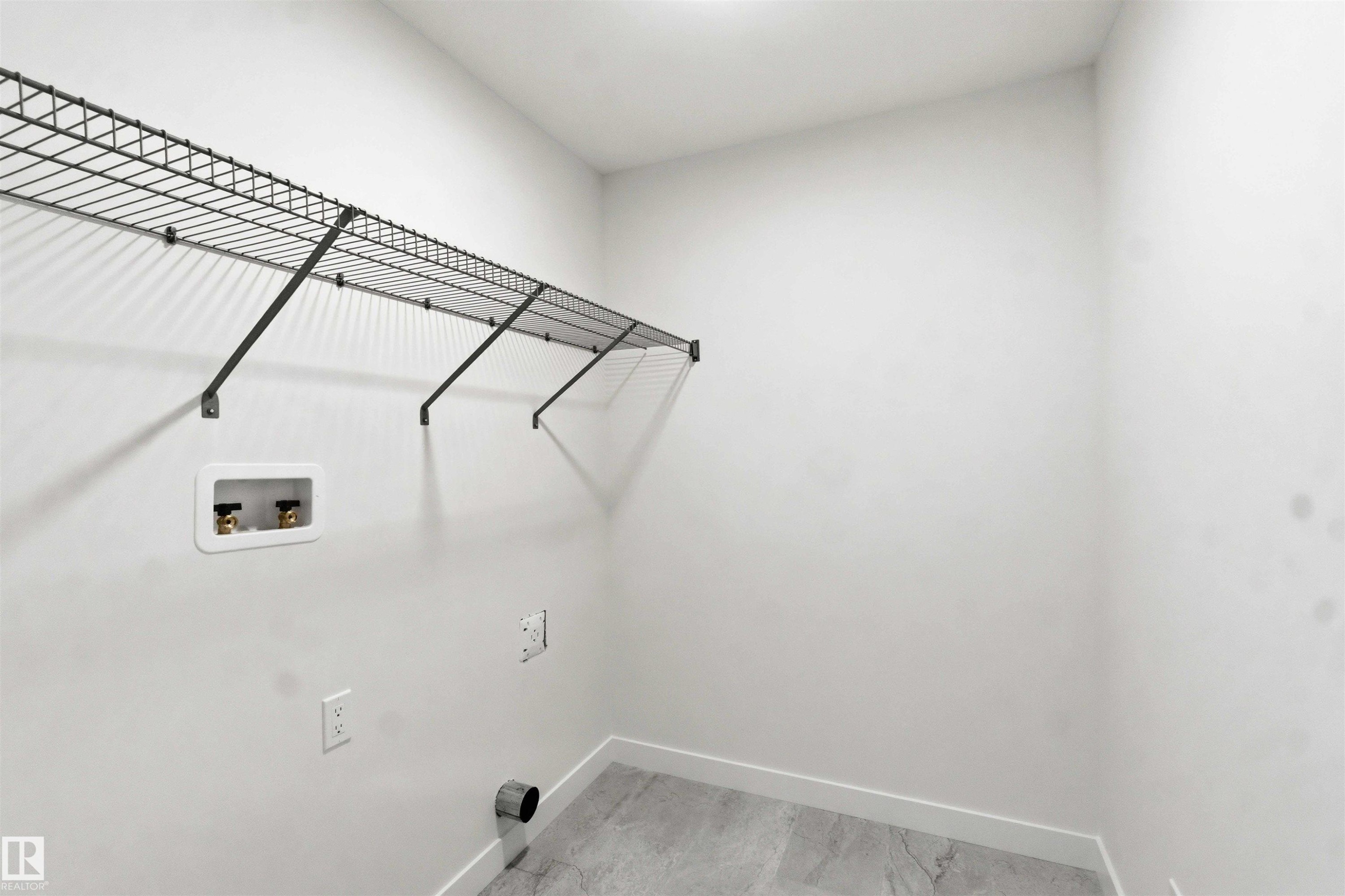 Utility space with wire shelving, light-toned wall paint, and grey-hued flooring - 1085 Cristall Crescent Sw, Edmonton, AB - Indoor
