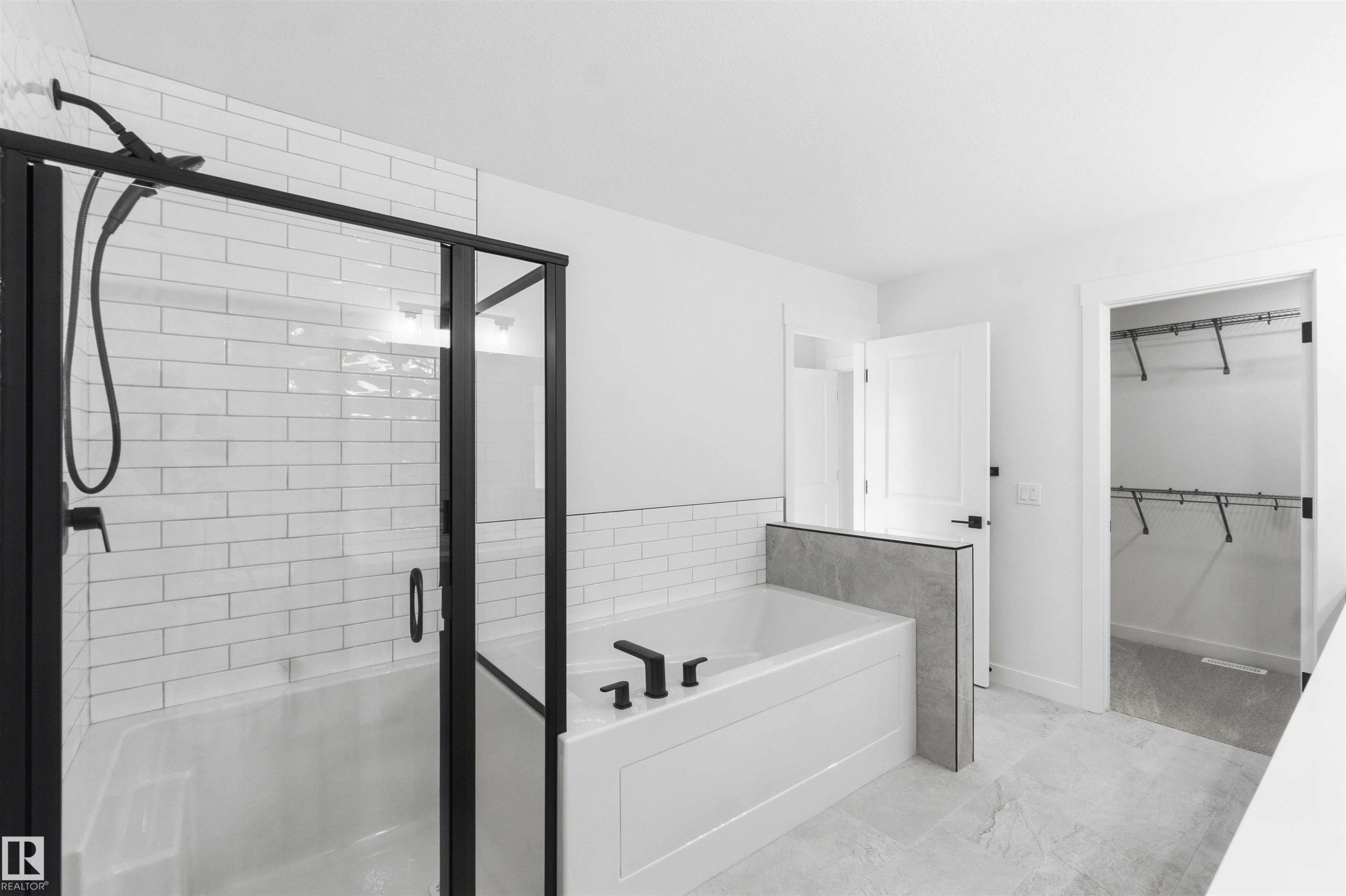 Bathroom featuring a tiled tub-shower combination with matte black fixtures and frameless glass enclosure - 1085 Cristall Crescent Sw, Edmonton, AB - Indoor Photo Showing Bathroom