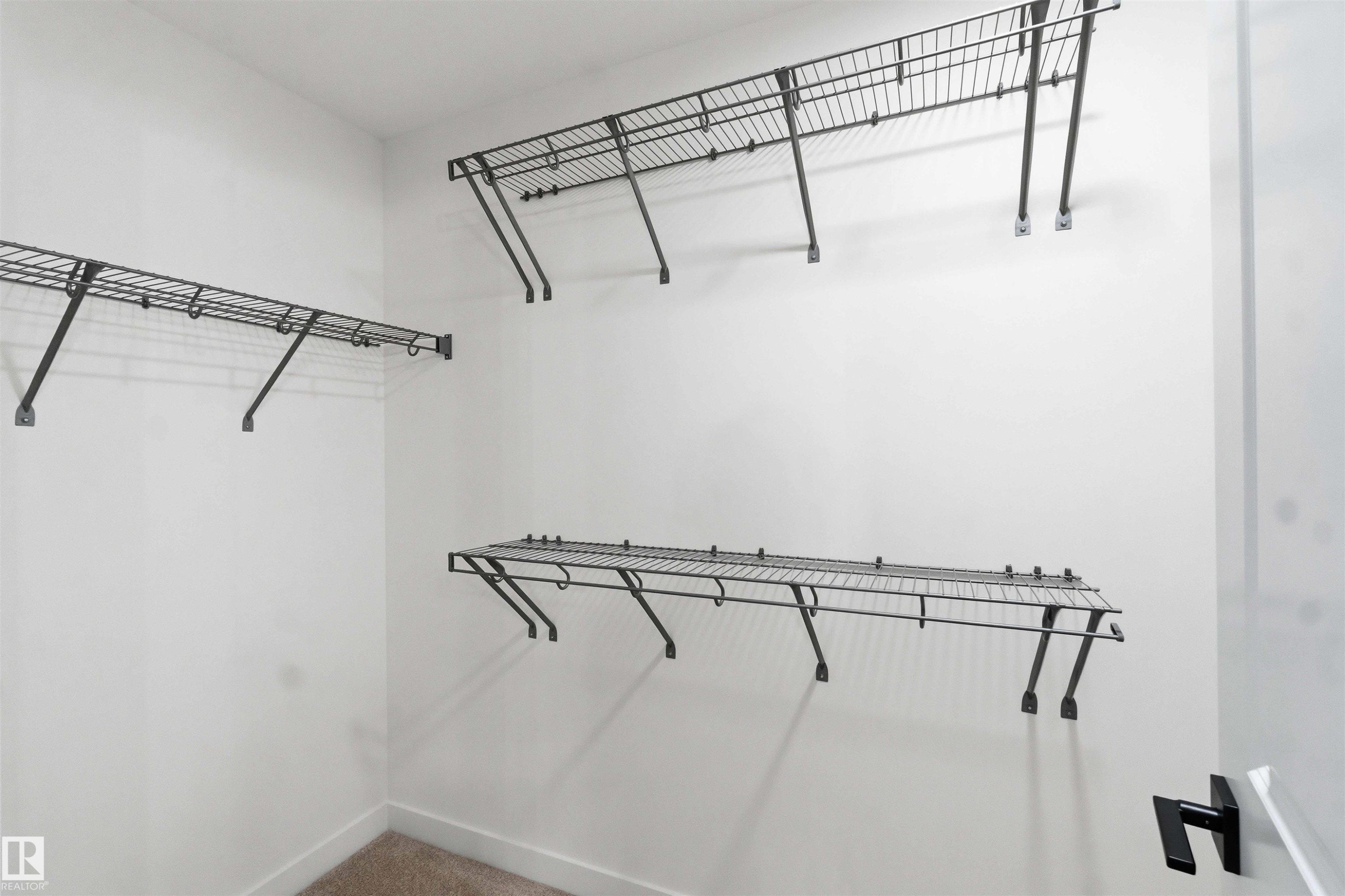 Ample storage solutions featuring multiple wire shelving units and hanging rods - 1085 Cristall Crescent Sw, Edmonton, AB - Indoor With Storage