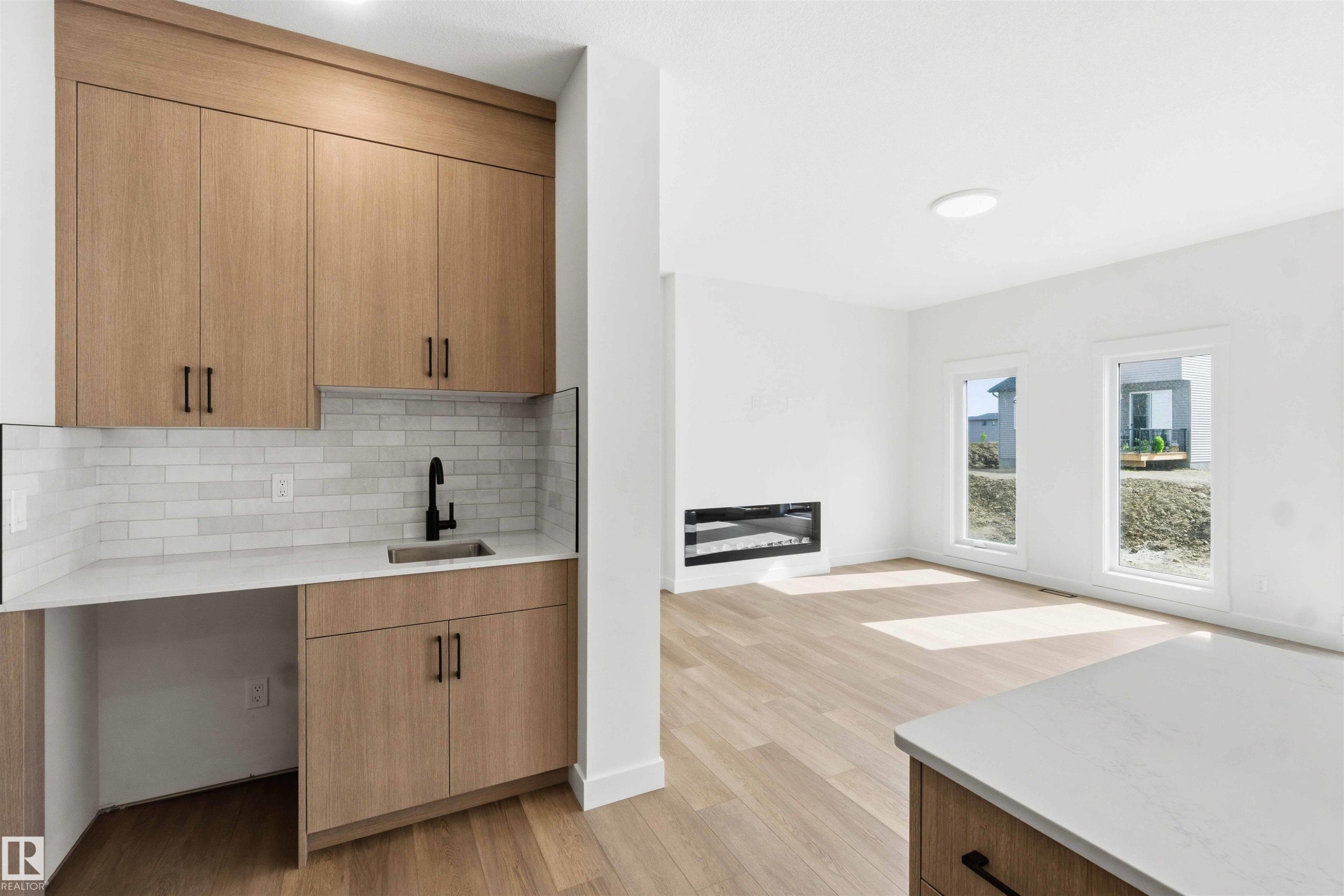 Integrated wet bar featuring wood-finish cabinetry, white countertop, and subway tile backsplash - 1085 Cristall Crescent Sw, Edmonton, AB - Indoor