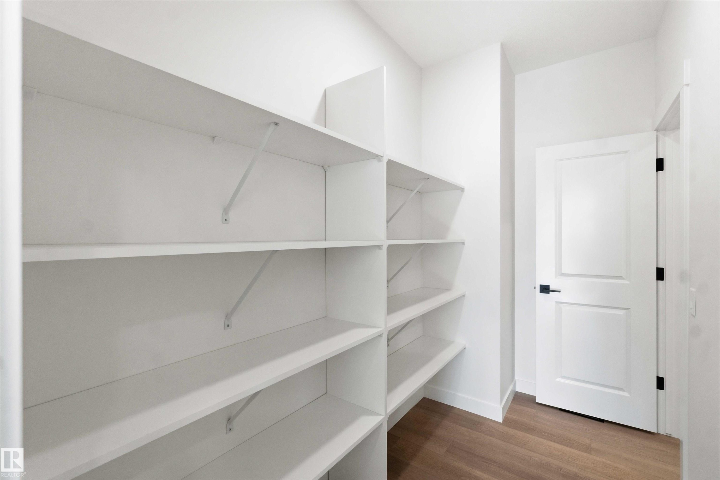 Walk-in pantry featuring extensive white shelving - 1085 Cristall Crescent Sw, Edmonton, AB - Indoor With Storage