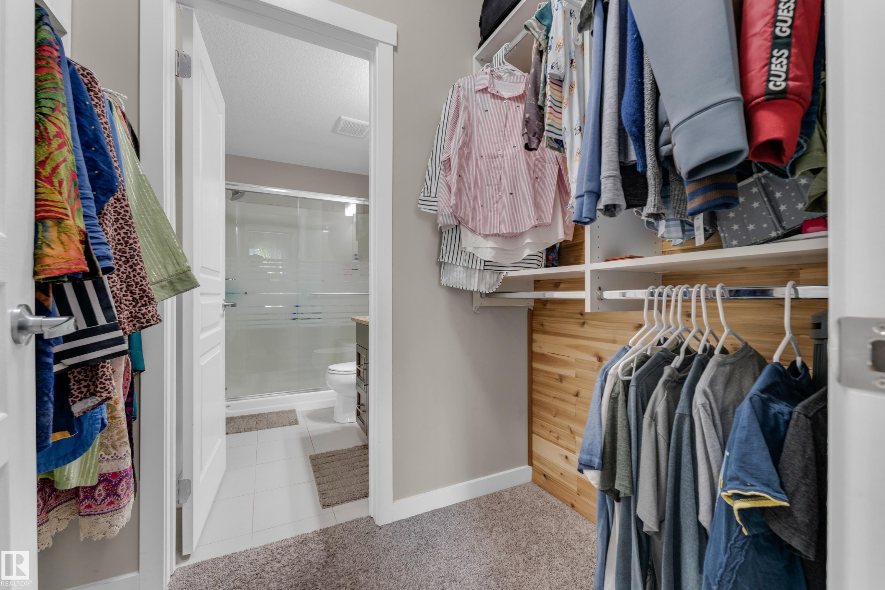 Expansive walk-in closet featuring built-in shelving, hanging rods, and a cedar-paneled accent wall - 115 812 Welsh Drive Sw, Edmonton, AB
