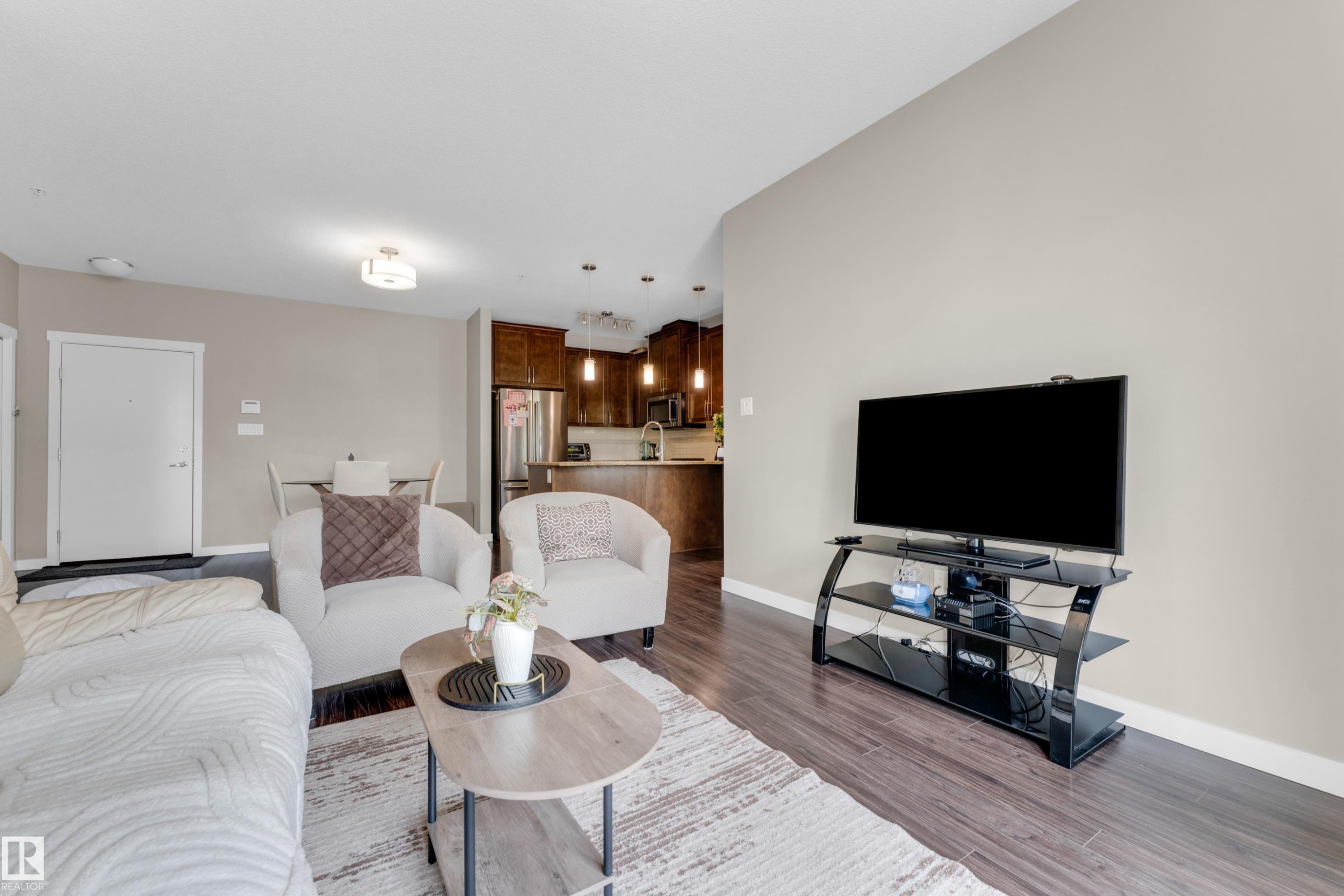 Living area featuring dark wood-finish flooring, light-toned walls, and recessed lighting - 115 812 Welsh Drive Sw, Edmonton, AB