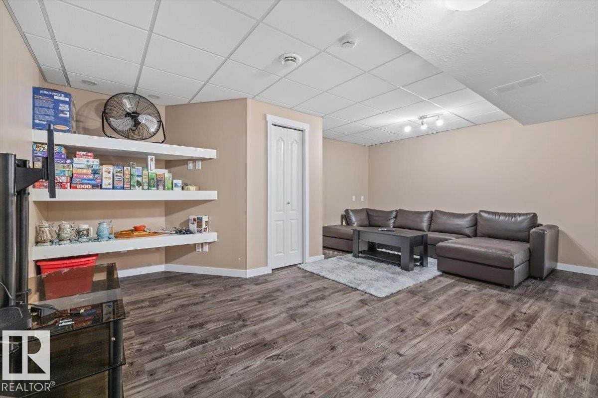 Expansive finished lower level featuring wood-finish flooring, neutral wall tones, and white baseboards - 4708 47A Avenue, Onoway, AB