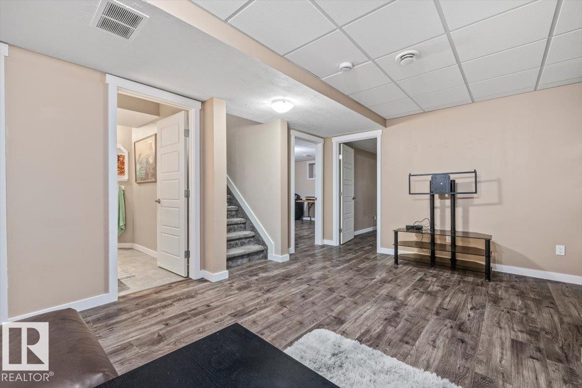 Room featuring wood-finish flooring, neutral wall paint, and white trim - 4708 47A Avenue, Onoway, AB