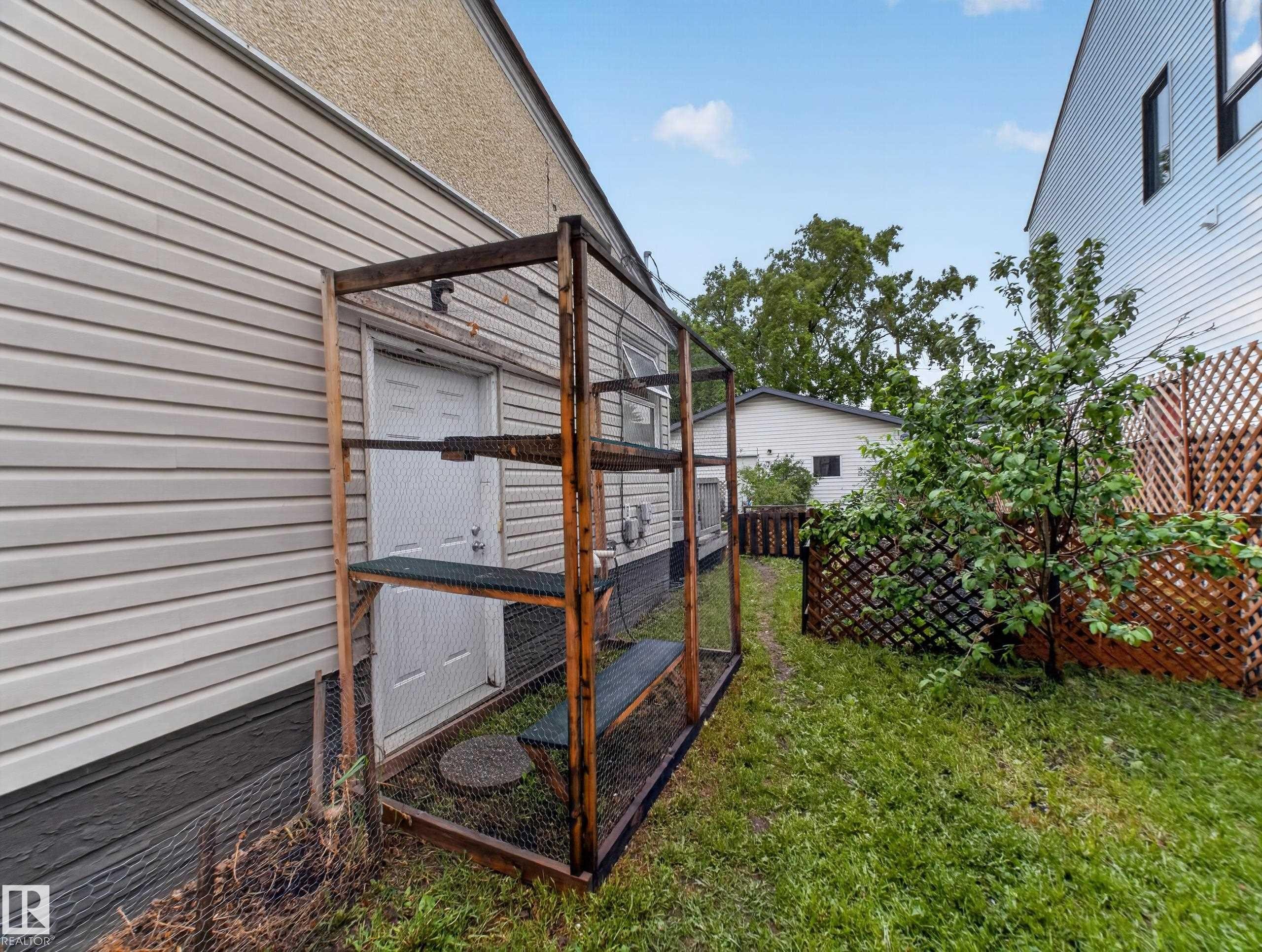 Side yard area featuring a built-in outdoor enclosure - 10809 150 Street, Edmonton, AB