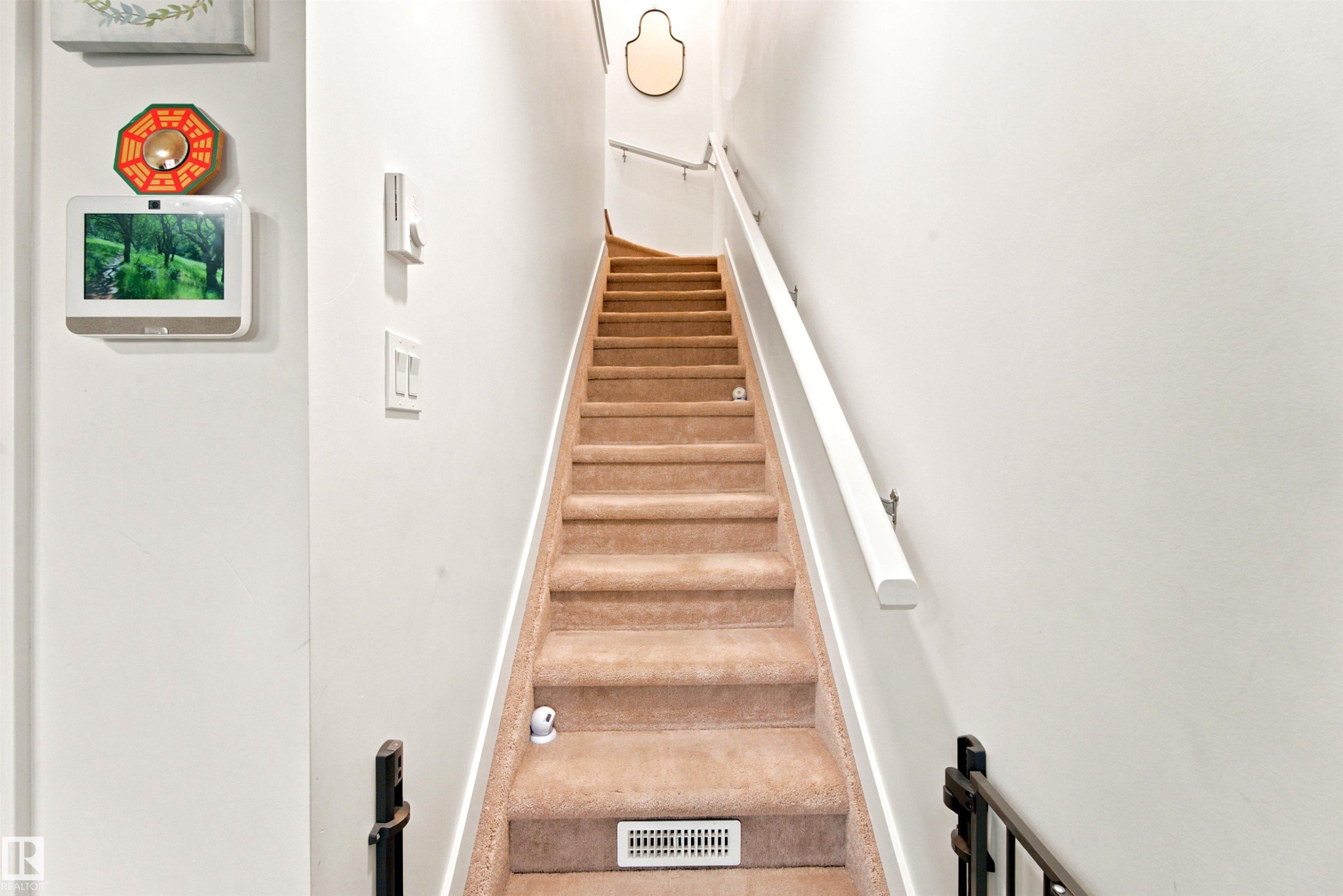 Carpeted staircase with white walls and a white handrail - 64 655 Watt Boulevard, Edmonton, AB